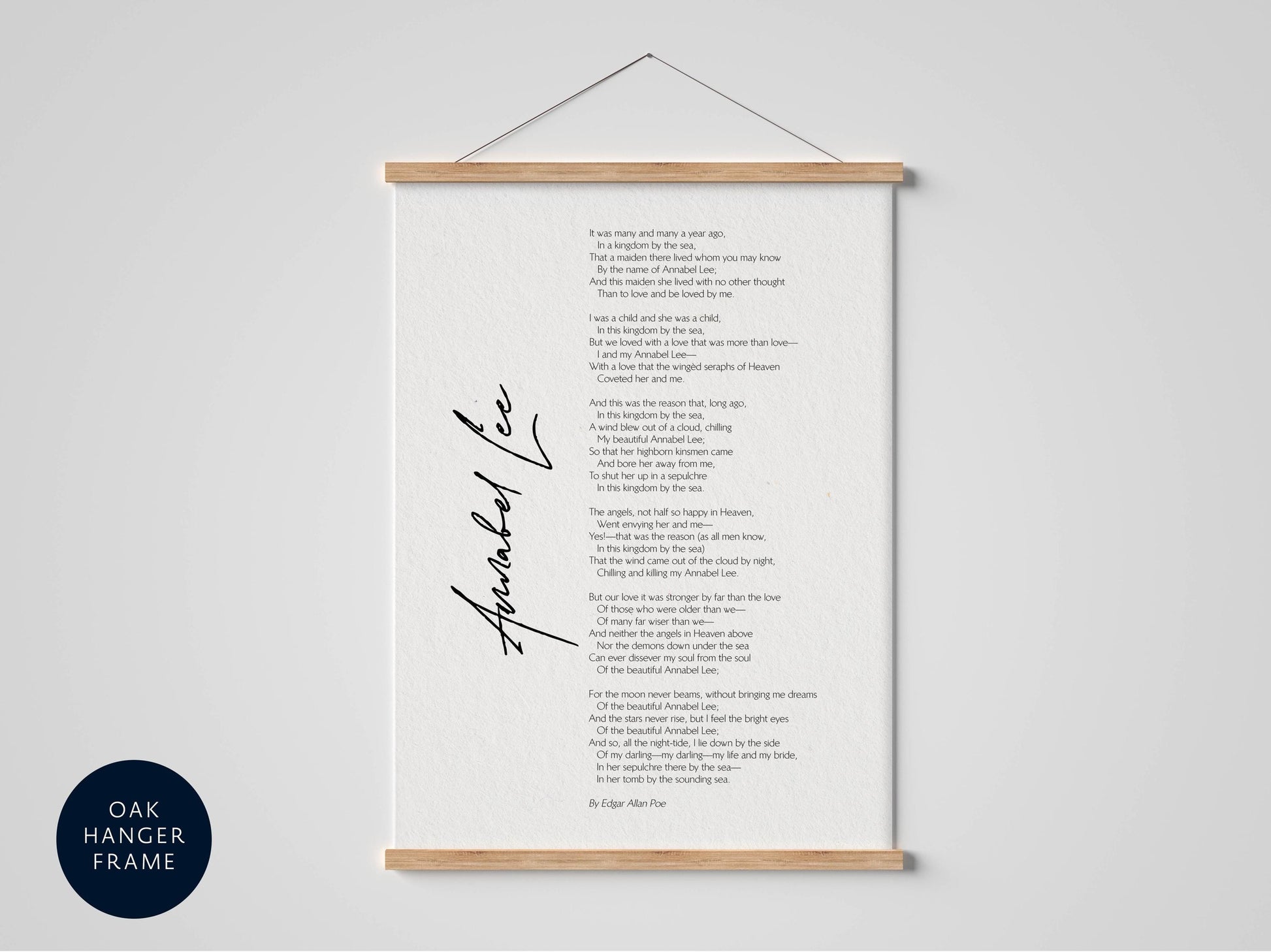 a framed poem titled "Anabel Lee" by Edgar Allan Poe, which is hanging on a wall. The poem is written in a flowing cursive font and is framed by a wooden hanger. The image does not contain any text or additional objects, and the focus is solely on the poem and its presentation.