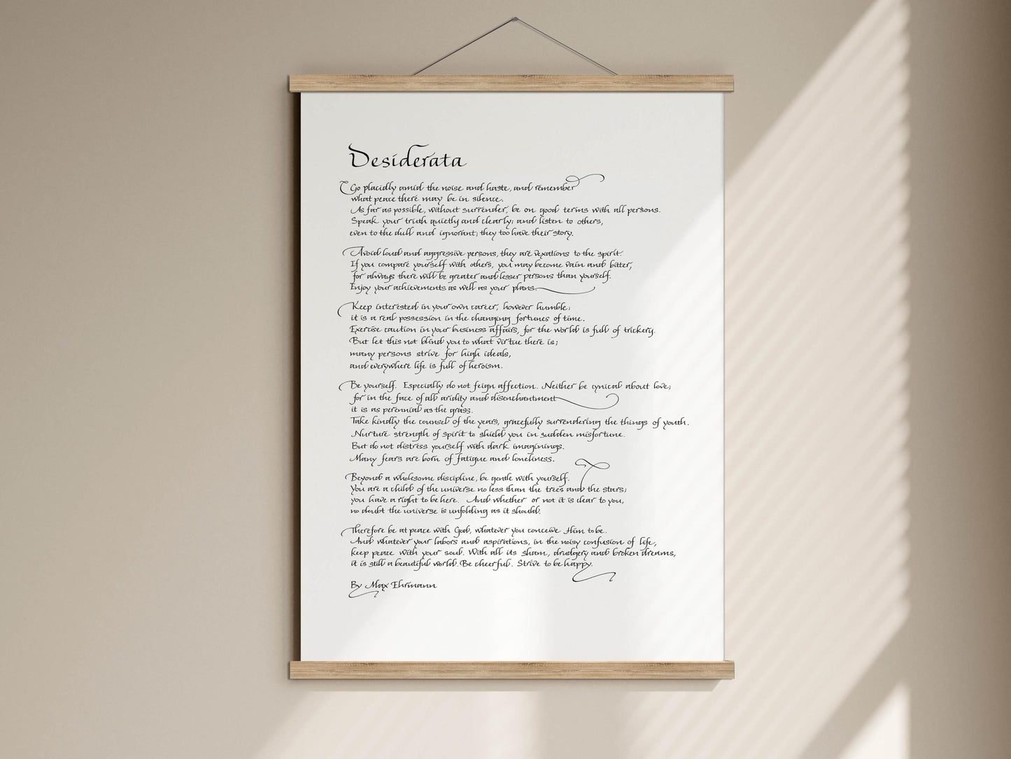 a handwritten poem on a white scroll, which is mounted on a wall.