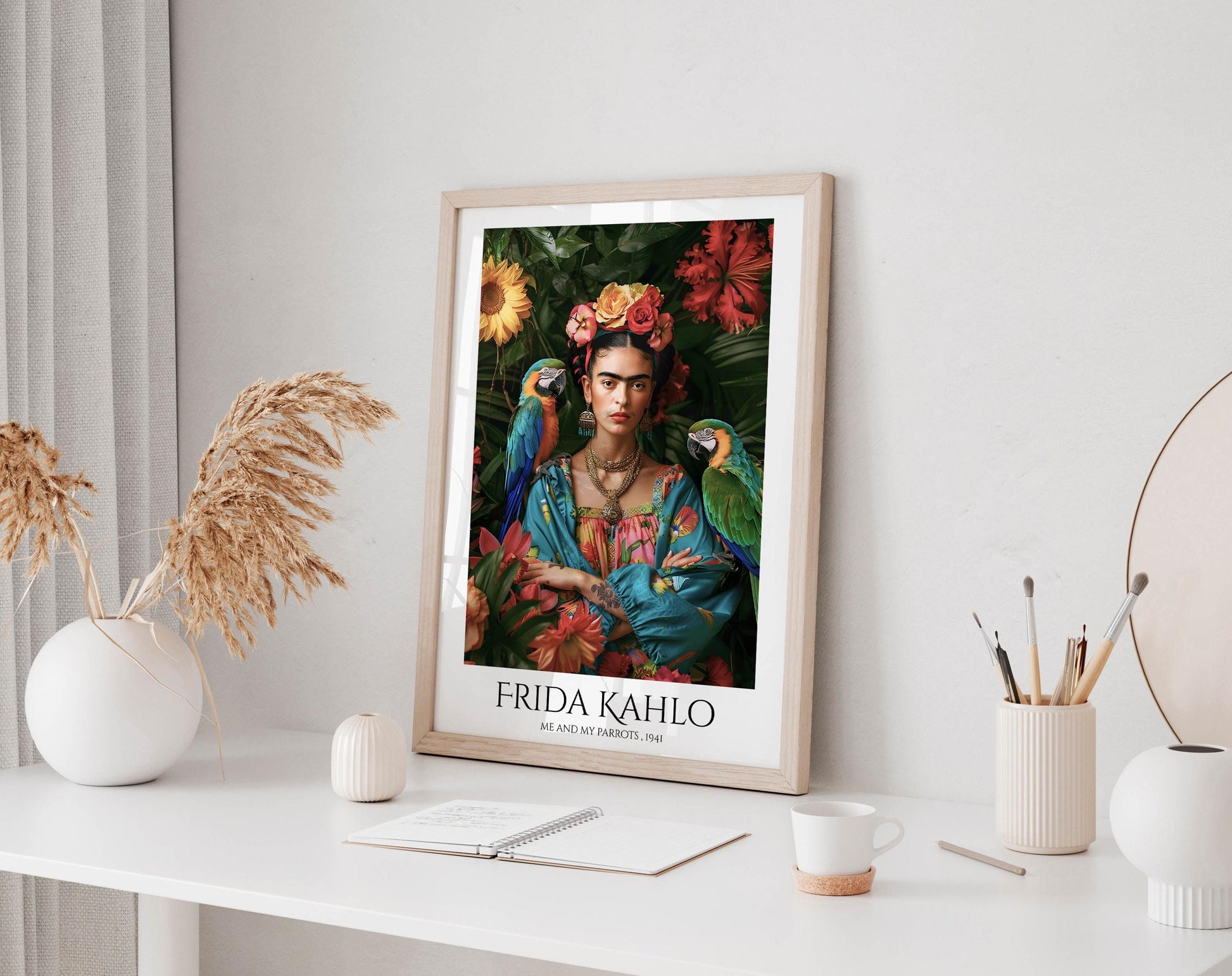 a framed poster of Frida Kahlo, a famous Mexican artist, displayed on a white shelf. The poster is surrounded by various objects, including a white vase, a small white candle, a white mug, and a white notebook.