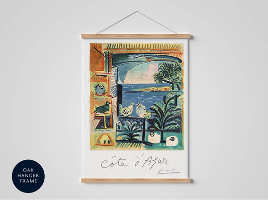 The image is a framed artwork depicting a colorful and vibrant scene with various elements such as birds, palm trees, and a body of water.
