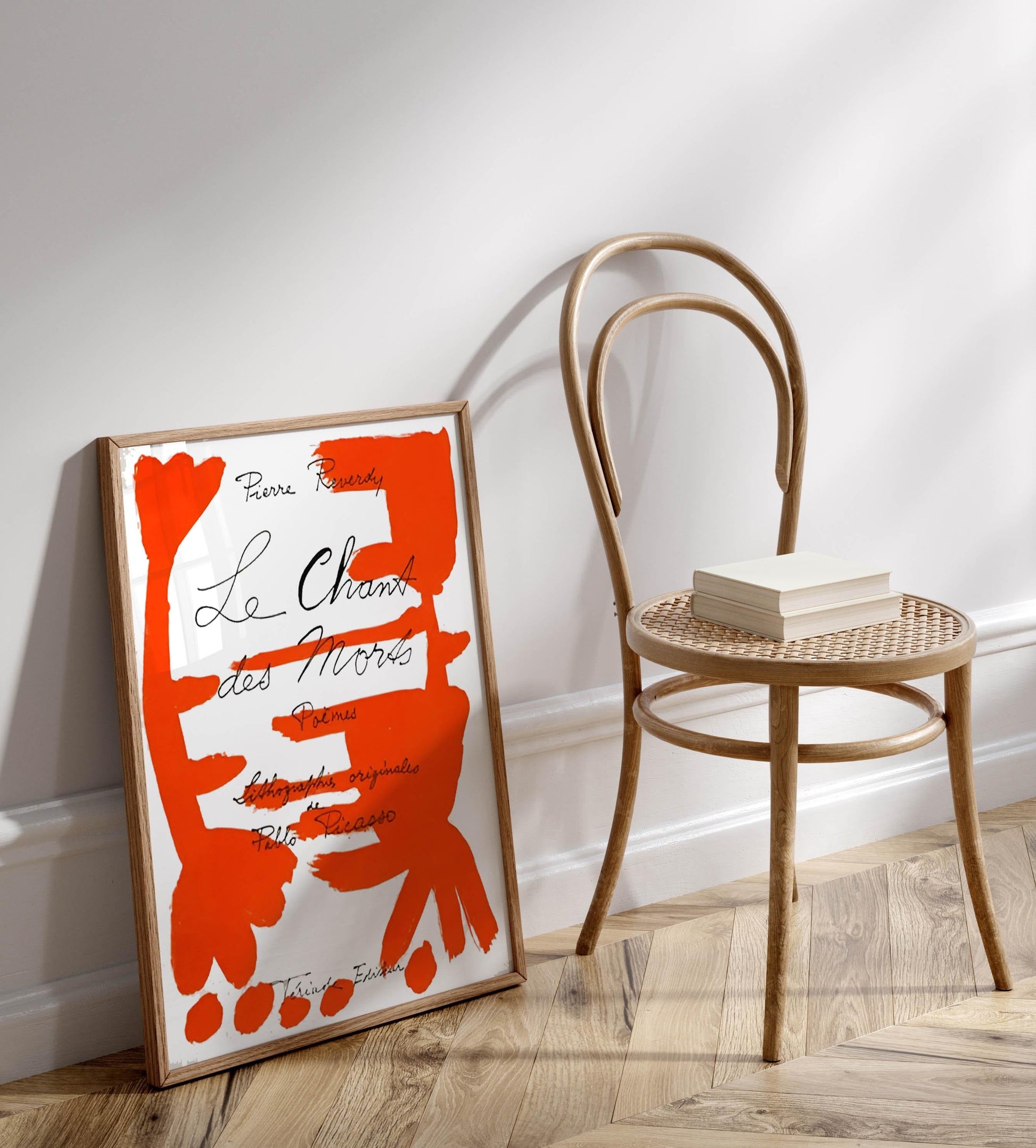 a poster of a book titled "Le Chêne des Morts" by Pierre Resourcy, leaning against a wall next to a wooden chair.