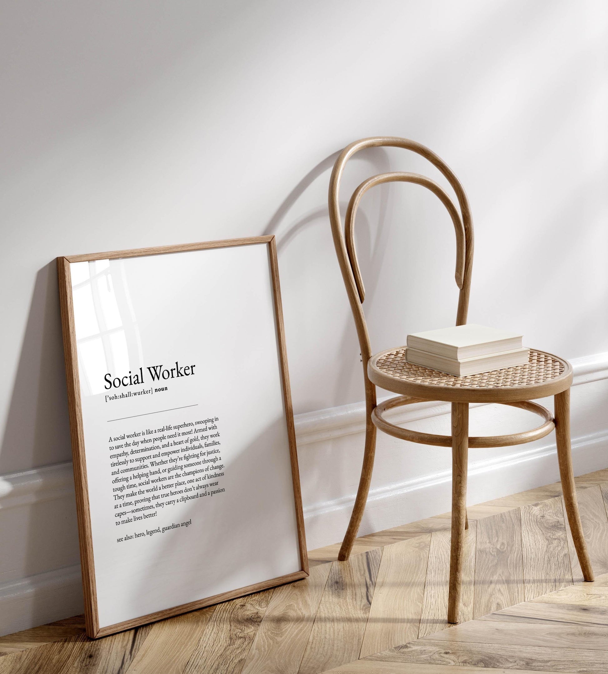 a wooden chair with a book on it, placed on a wooden floor next to a framed definition of a social worker.