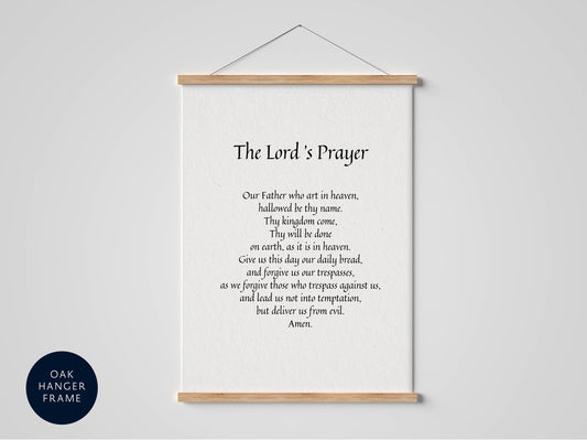 a framed prayer poster with a black and white design, hanging on a wall.