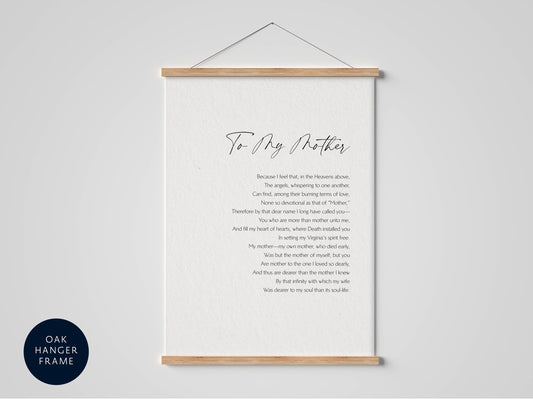 a framed print with a poem titled "To My Mother" written in cursive. The poem is about the love and bond between a mother and her child, expressing feelings of love, loss, and the passage of time. The poem is presented in a black and white color scheme, with the title and poem text written in a cursive font. The frame is hanging on a wall, and the text is centered within the frame.