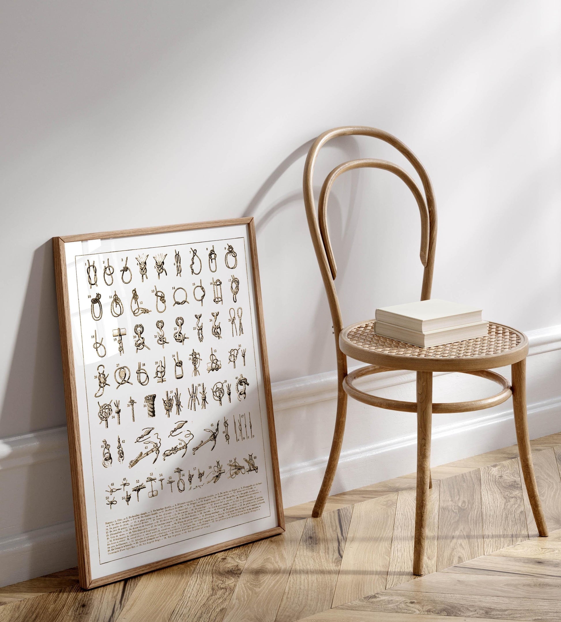 a wooden chair with a book resting on it, placed against a white wall.