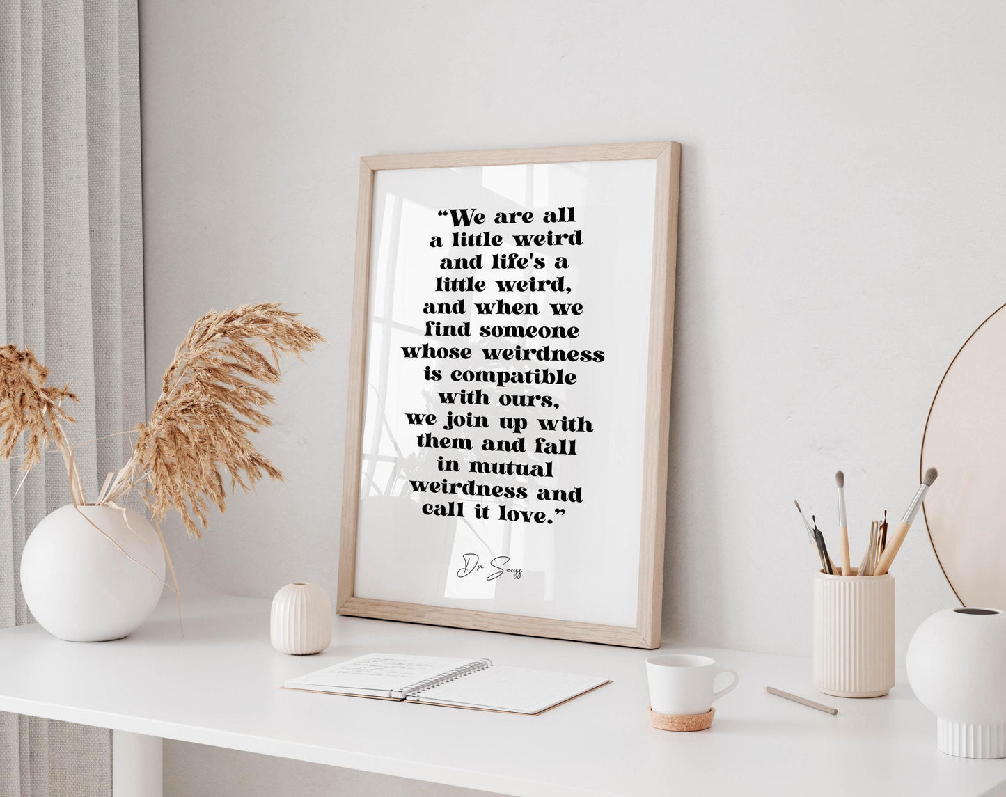 a framed quote by Dr. Seuss, which reads: "We are all a little weird and life's a little weird, and when we find someone whose weirdness is compatible with ours, we join up with them and fall in mutual weirdness and call it love."