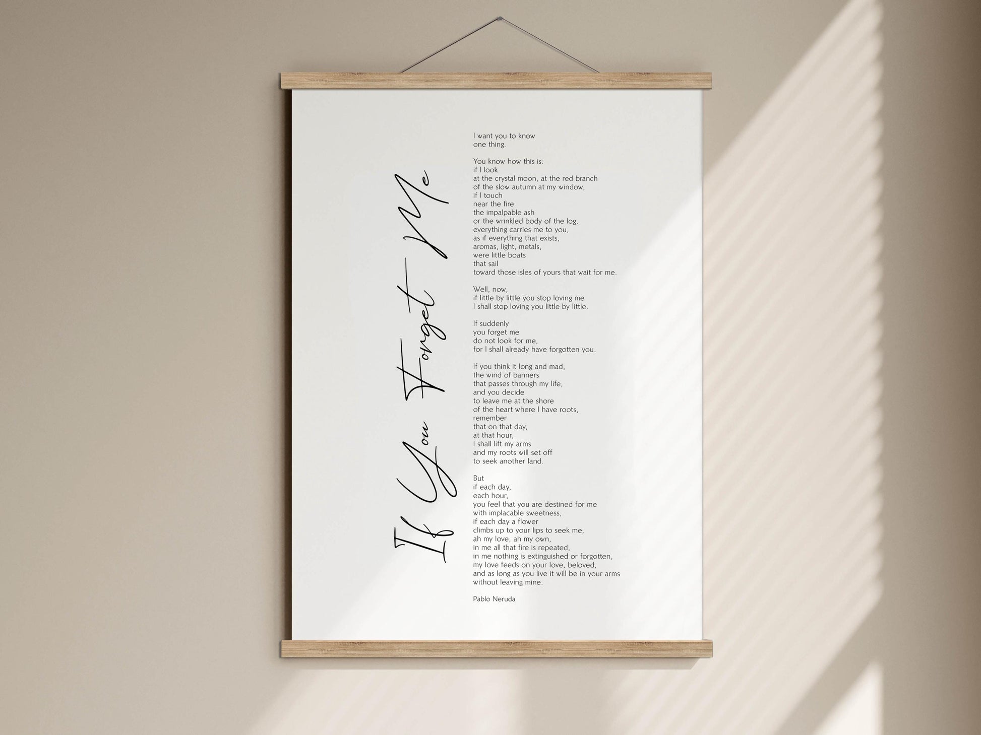 The image is a framed print of a poem titled "If You Forget Me" by Pablo Neruda. The poem is written in black cursive font and is displayed on a white wall.