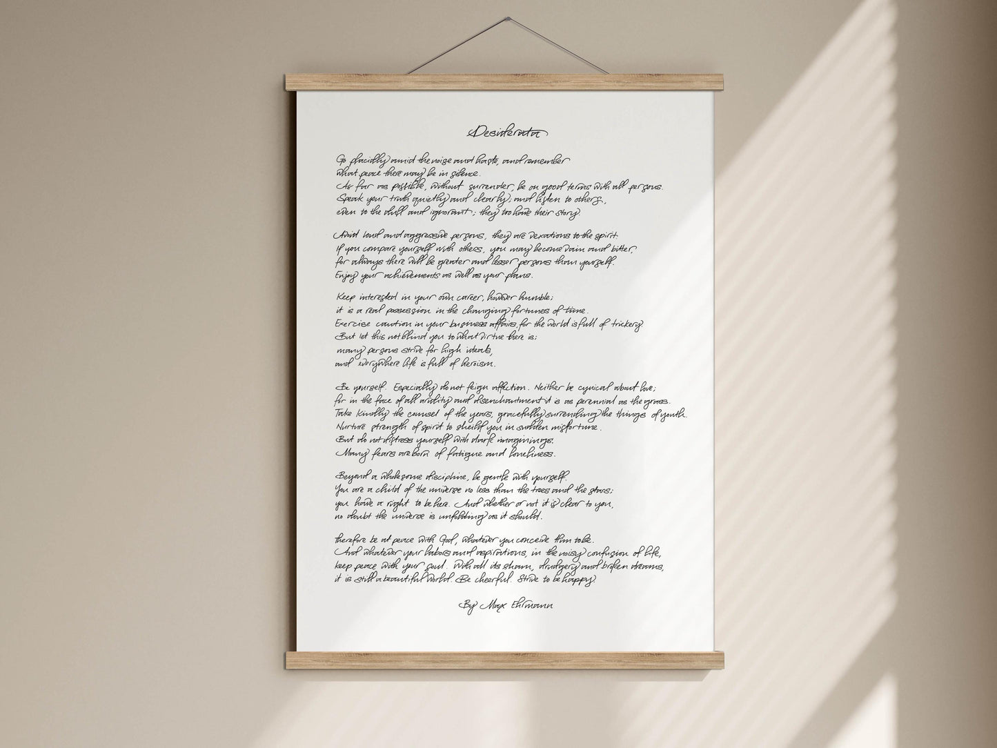 The image is a white poster with black handwritten text, which appears to be a poem or a song lyrics. The text is written in cursive and is displayed on a wooden frame.