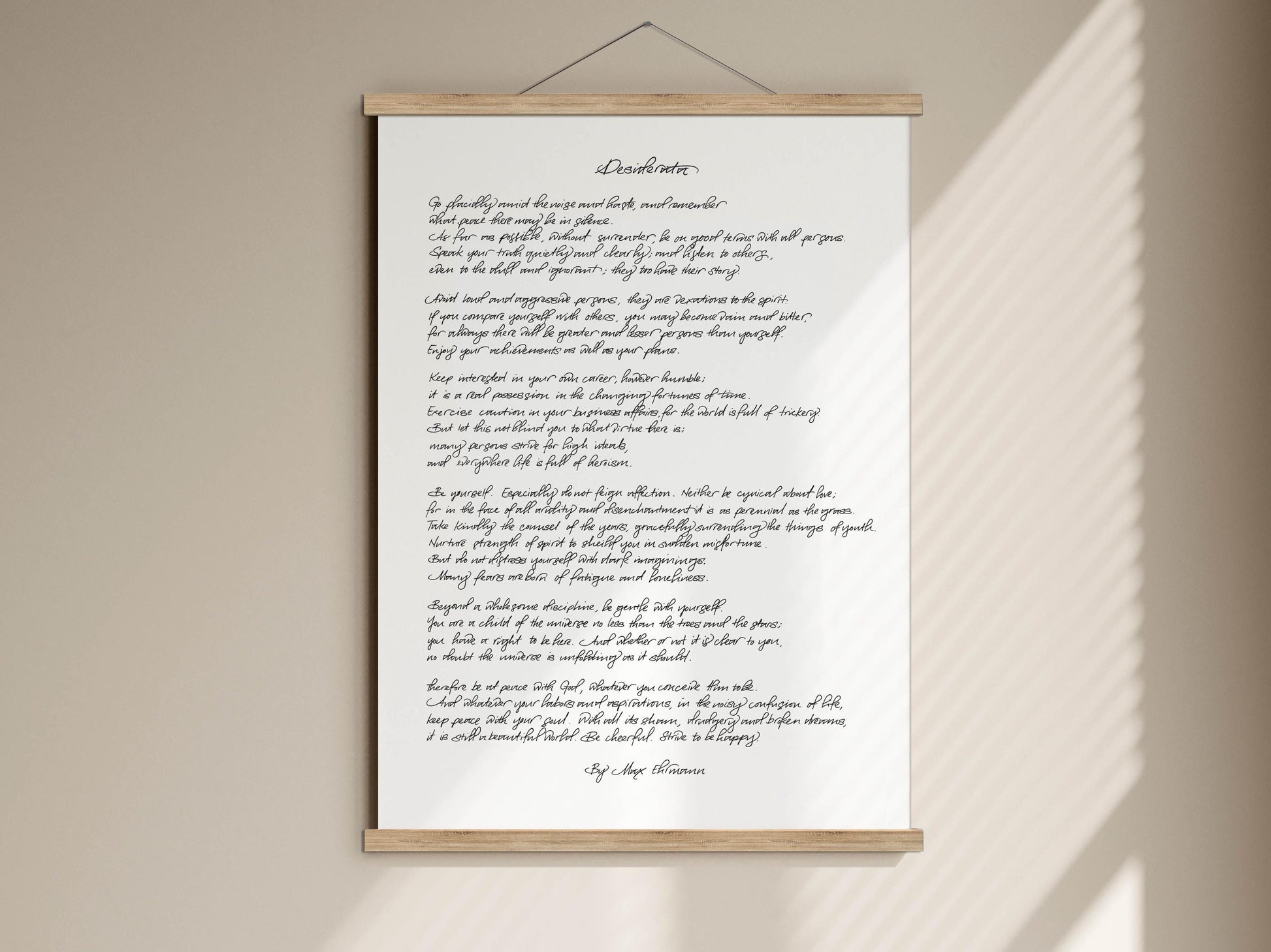 The image is a white poster with black handwritten text, which appears to be a poem or a song lyrics. The text is written in cursive and is displayed on a wooden frame.