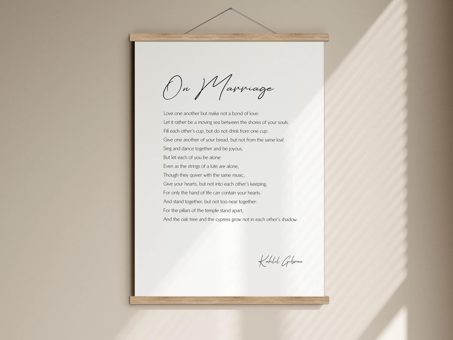 a poster with a poem titled "On Marriage" written in black cursive font. The poster is mounted on a wall and features a wooden frame.