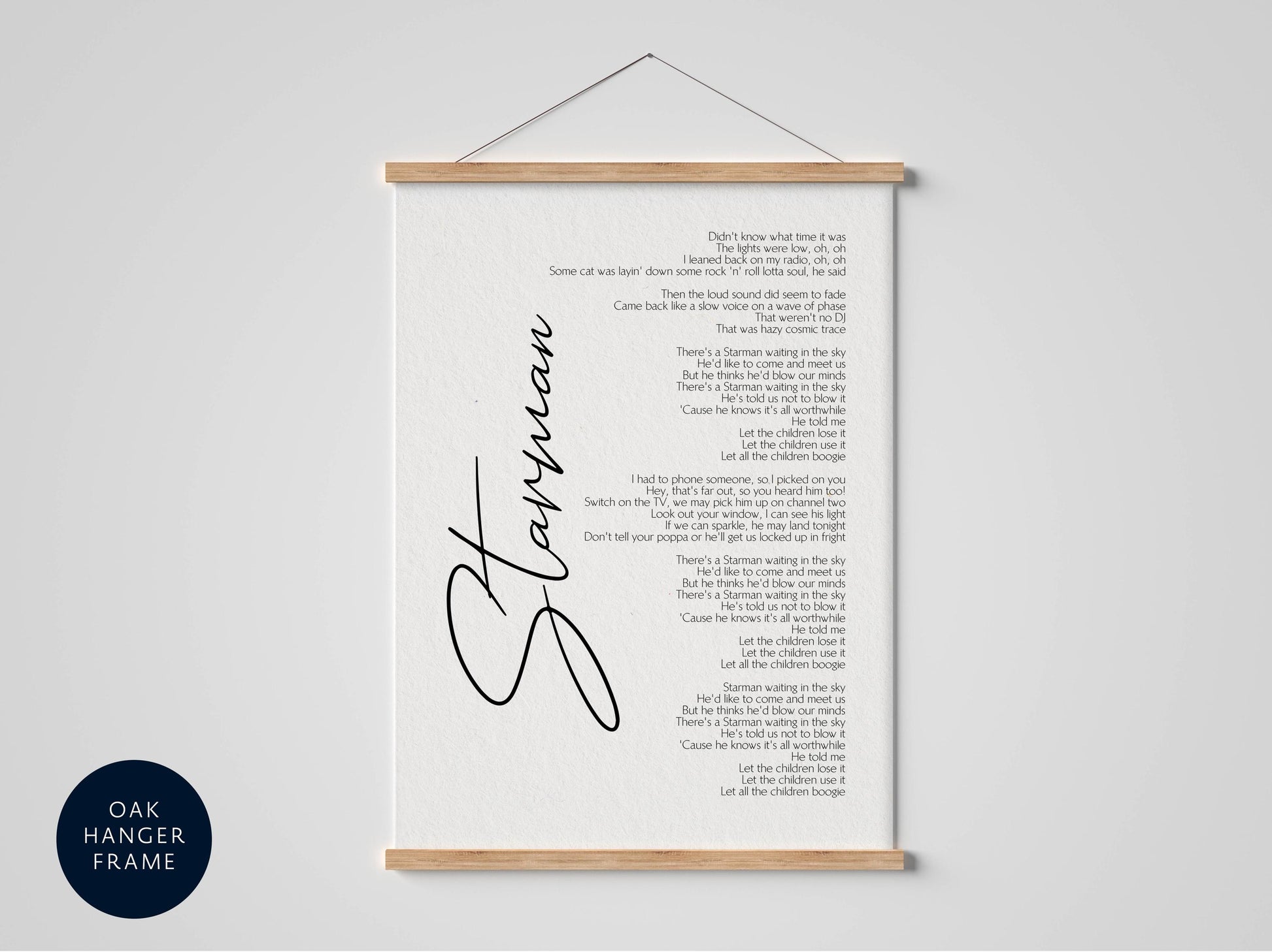 The image is a framed poster with a black and white design, featuring a list of lyrics or a poem. The text is written in a cursive font and is arranged in a vertical orientation. The poster is hanging on a wall, and there is a blue circle with text at the bottom left corner.