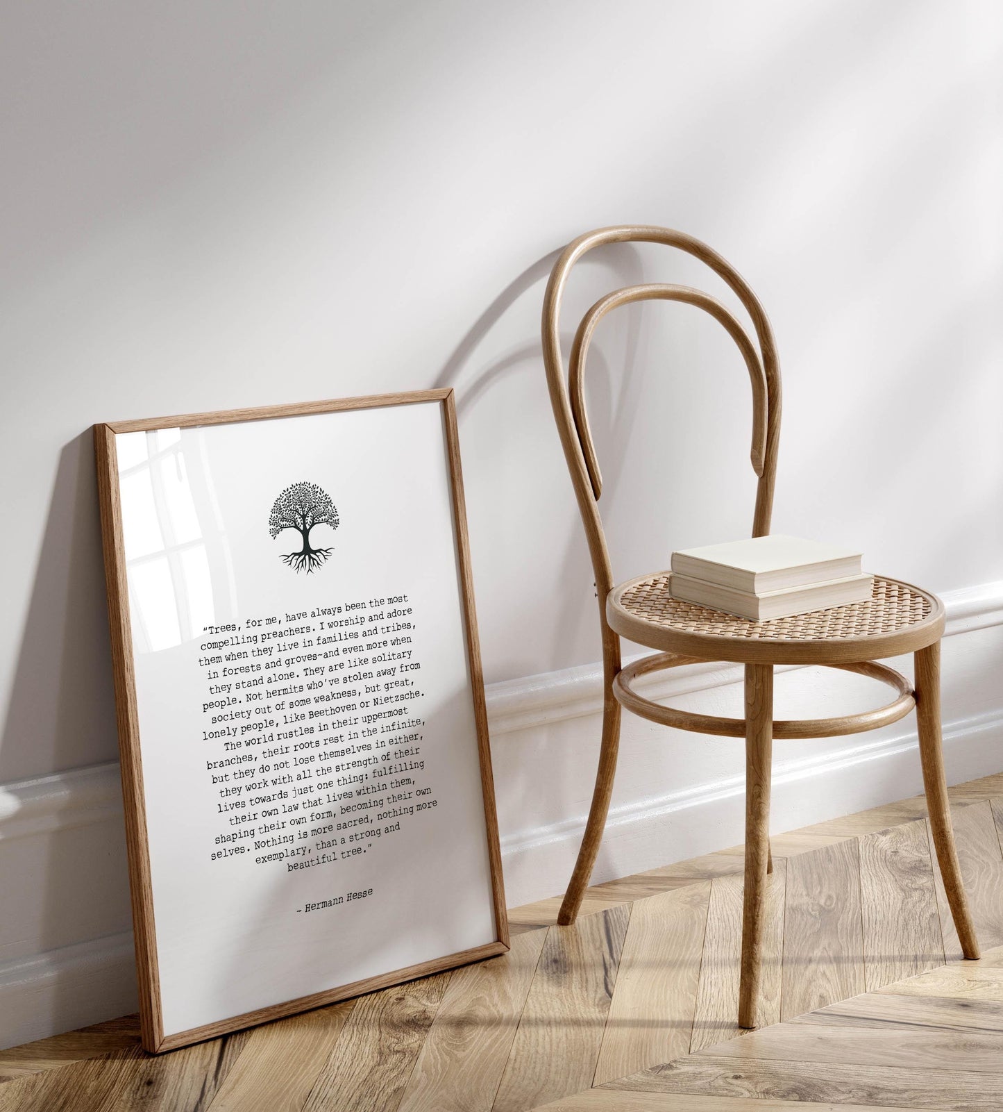 a wooden chair with a book on it, placed on a wooden floor next to a framed quote.
