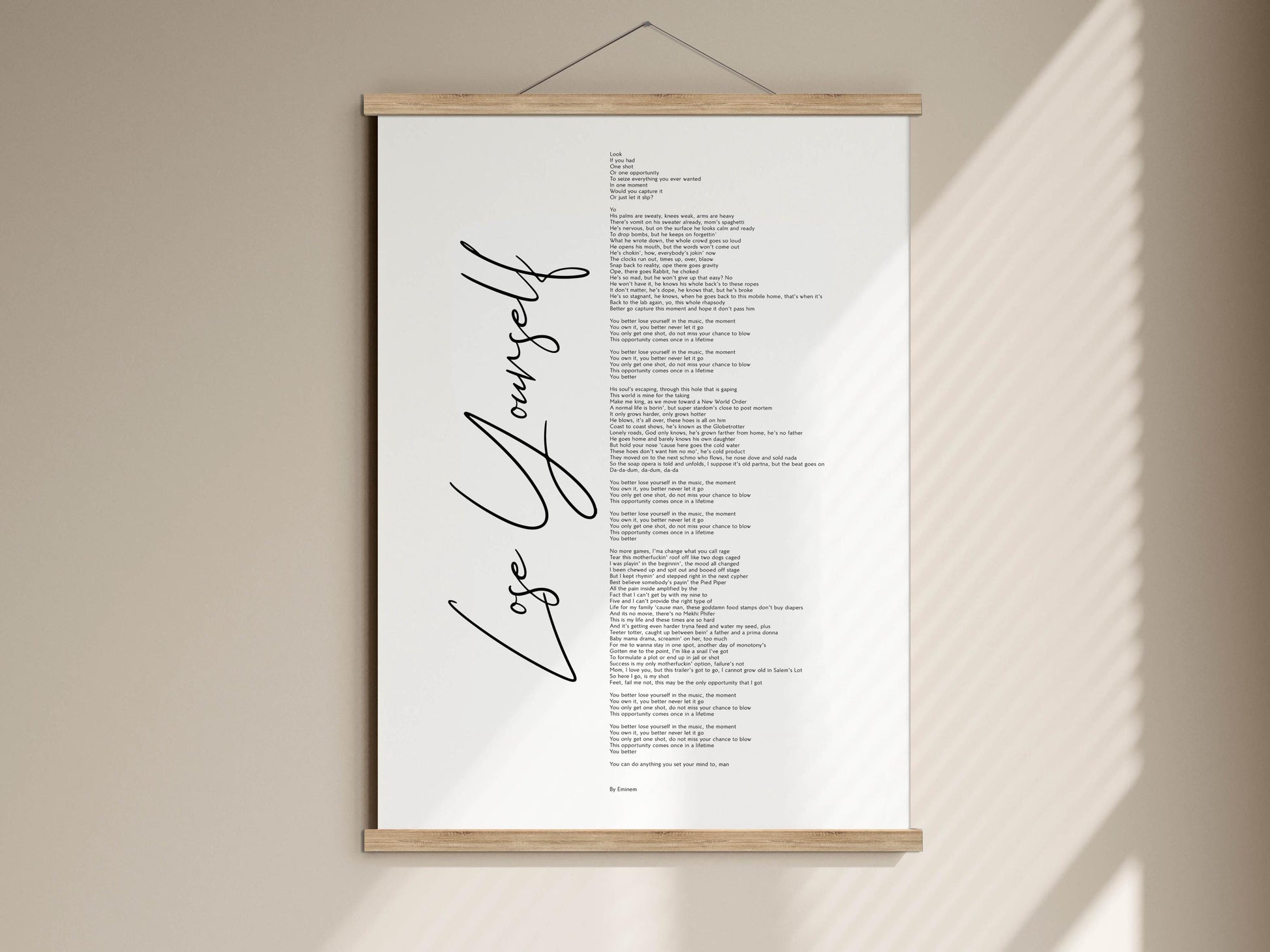 The image is a poster with the text "Lose Yourself" written on it, hanging on a wall.