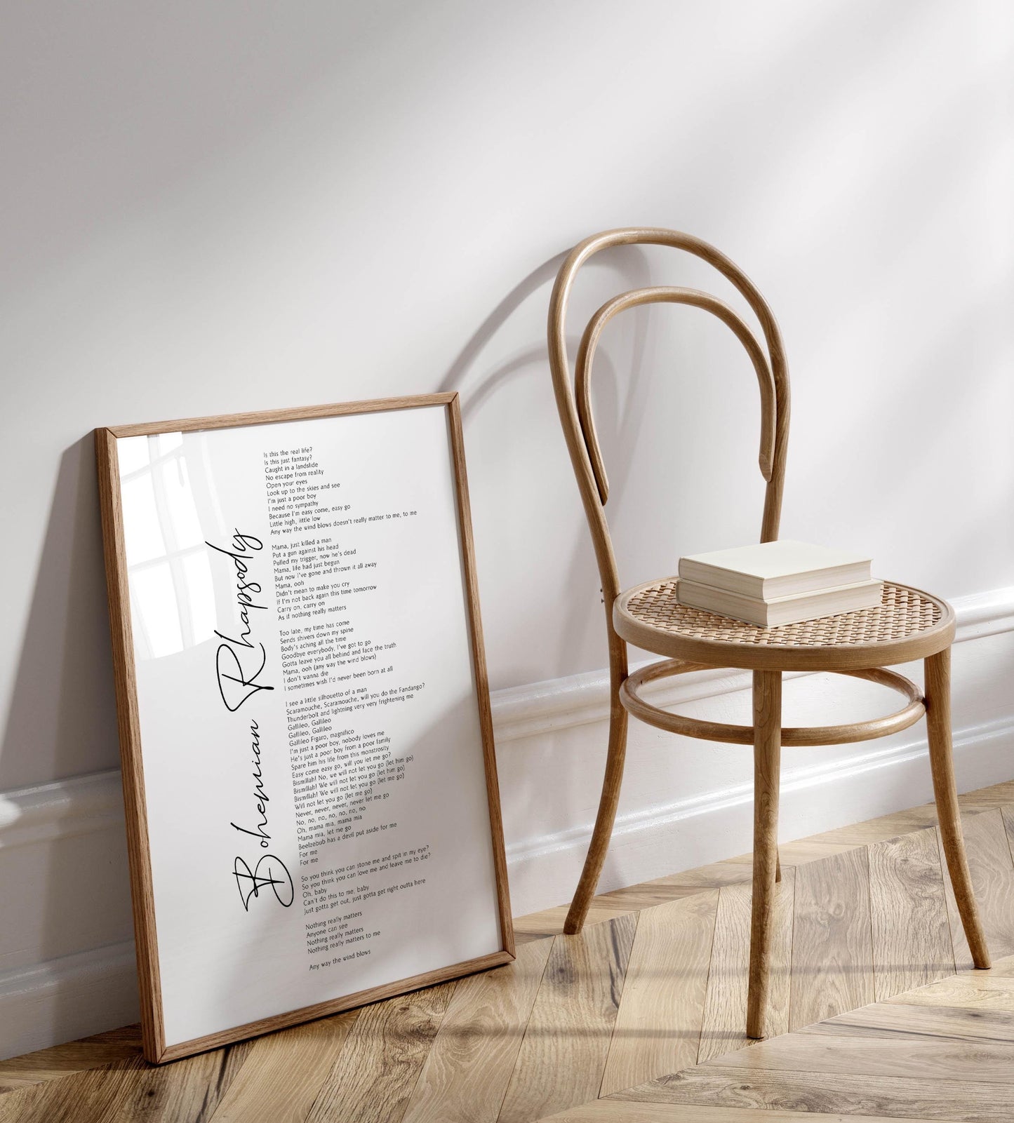 a wooden chair with a stack of books on it, placed against a white wall.