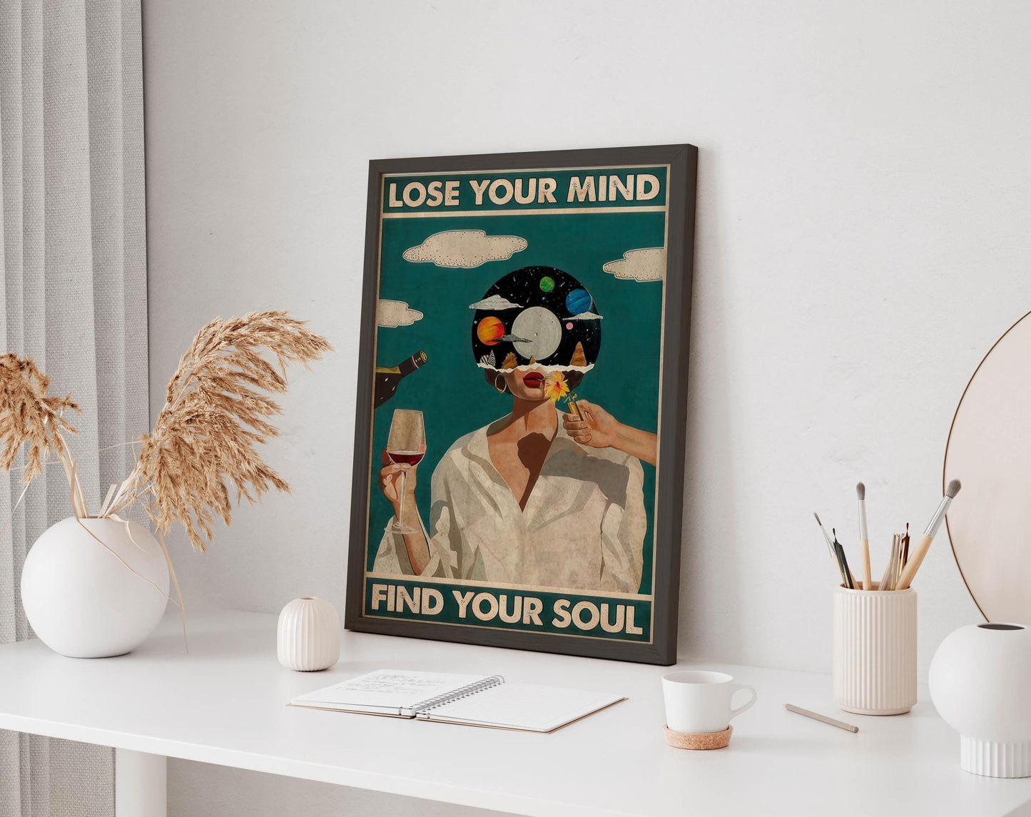a framed poster with the text &quot;LOSE YOUR MIND FIND YOUR SOUL&quot; displayed on a white wall above a desk with various items on it, including a notebook, a cup, and a vase.