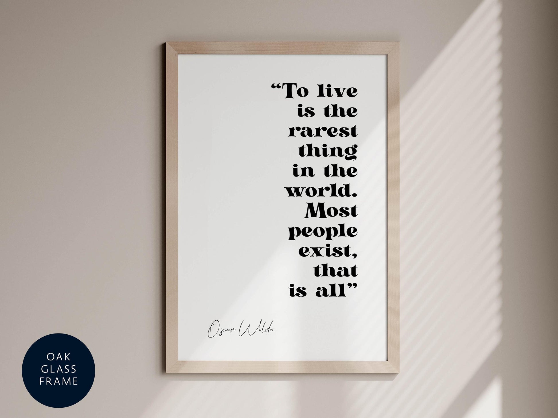 a quote by Oscar Wilde, &quot;To live is the rarest thing in the world. Most people exist, that is all.&quot; The quote is displayed in a framed format on a wall.