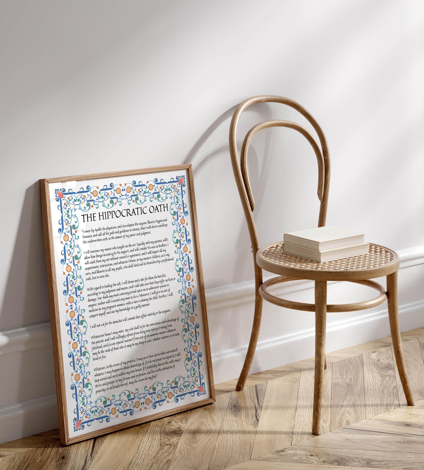 a framed poster with text and a decorative border, placed next to a wooden chair on a wooden floor.