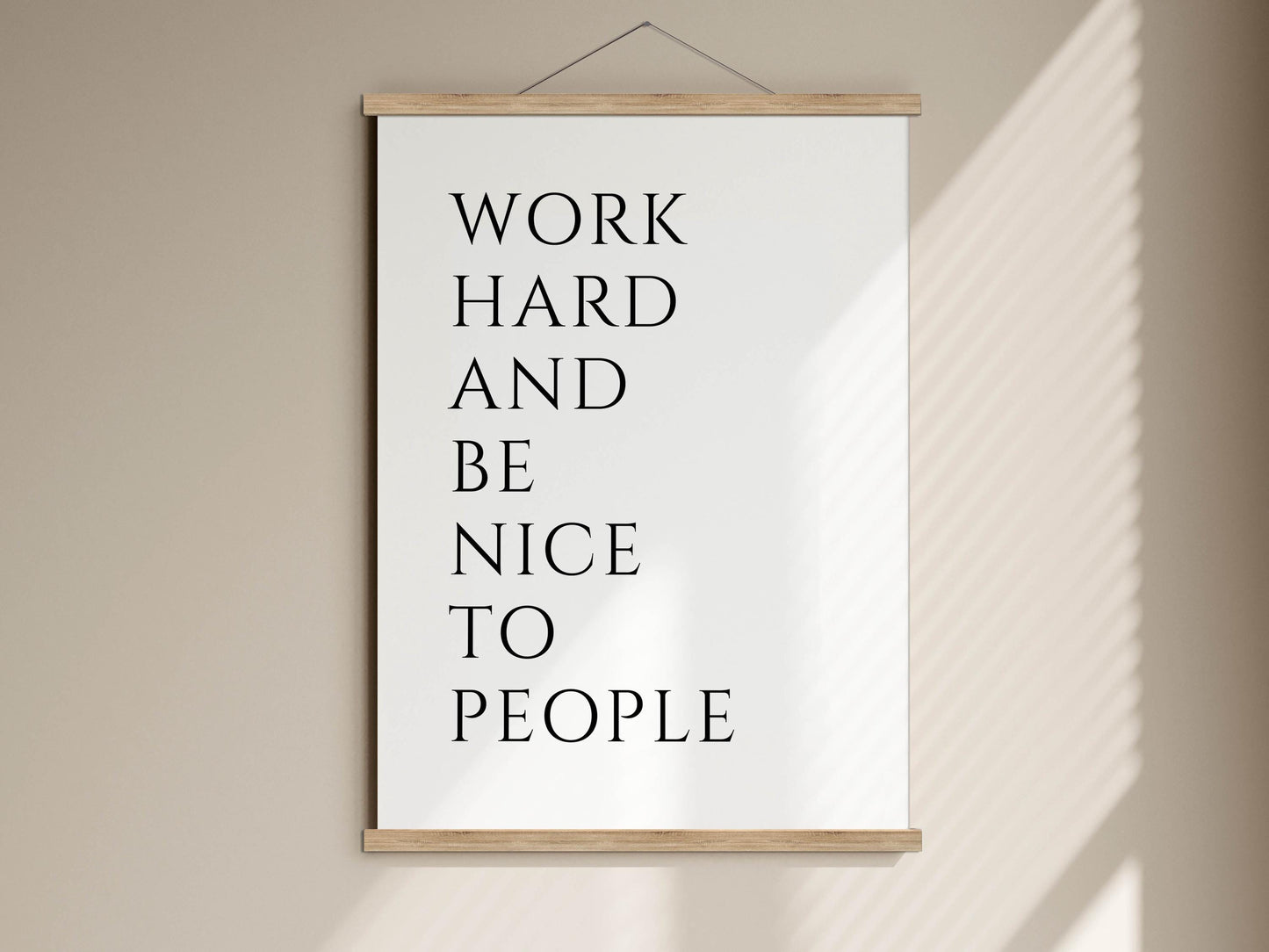 a motivational quote poster hanging on a wall, which reads &quot;WORK HARD AND BE NICE TO PEOPLE&quot;.