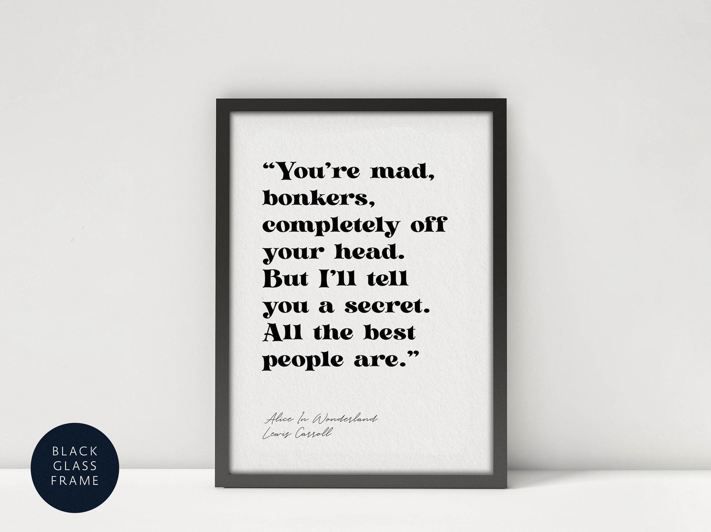 a framed quote from the book &quot;Alice in Wonderland&quot; by Lewis Carroll, which reads: &quot;You&#39;re mad, bonkers, completely off your head. But I&#39;ll tell you a secret. All the best people are.&quot;