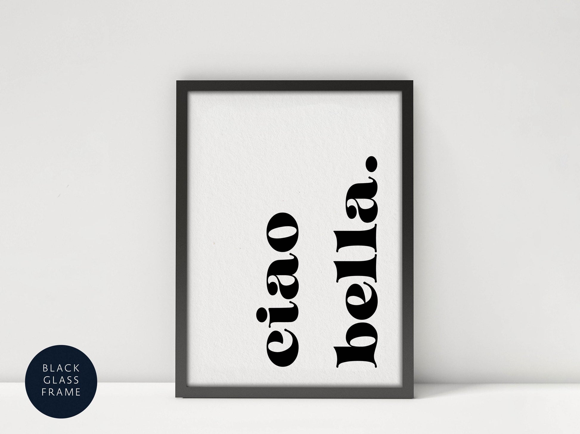 A framed poster with the text &quot;eiao bella&quot; in a bold, black font.