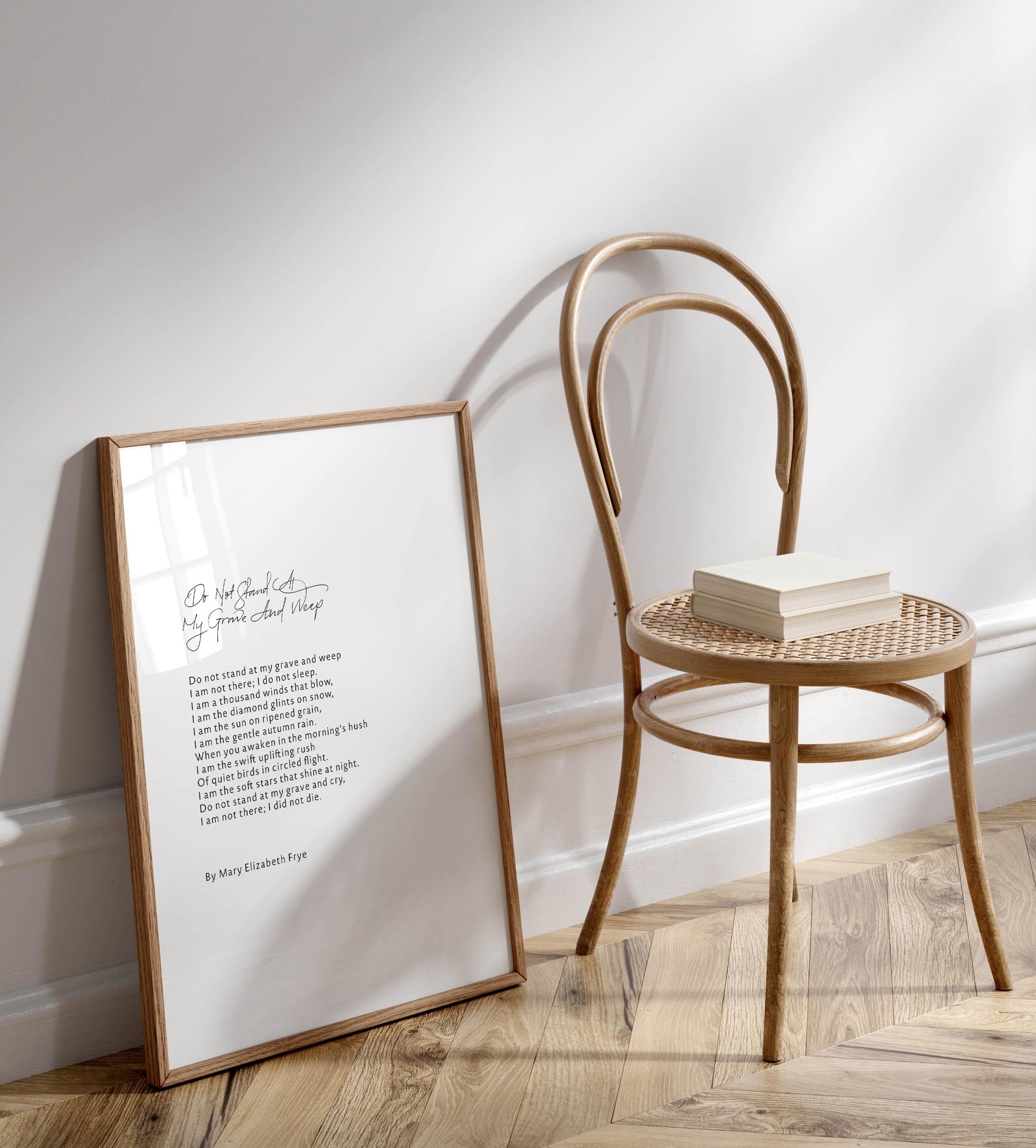 a framed poem titled &quot;Do not die, my love, do not die&quot; by Mary Elizabeth Frye, placed on a wooden floor next to a wooden chair.