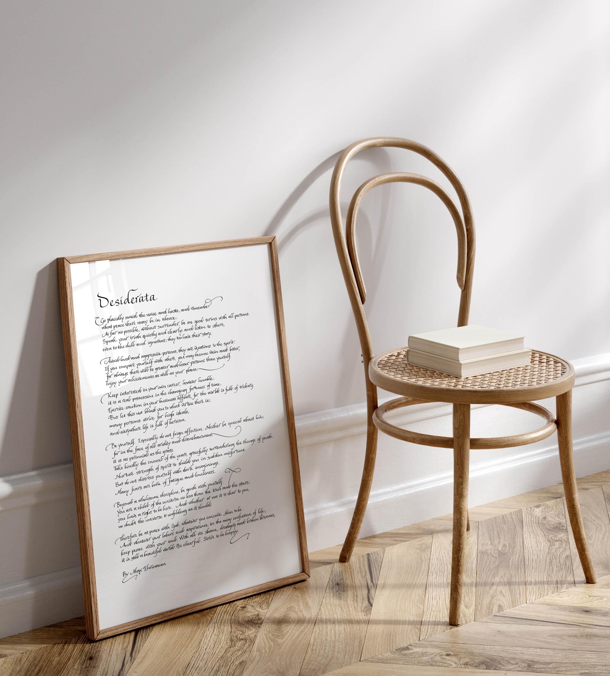 a wooden chair with a book resting on it, positioned next to a framed text that reads &quot;Desireada&quot;.