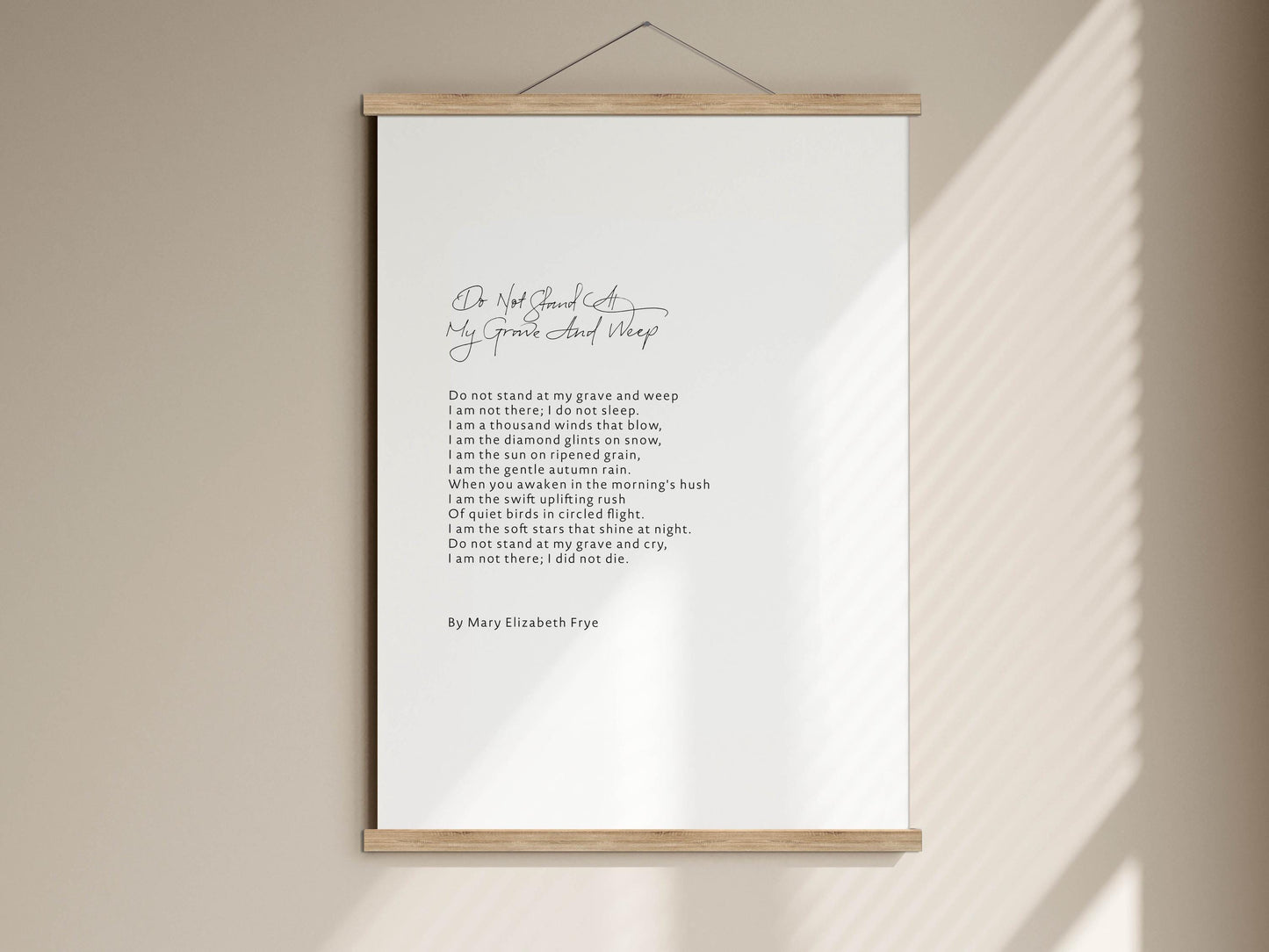 a white poster with a black handwritten poem on it, hanging on a wall.