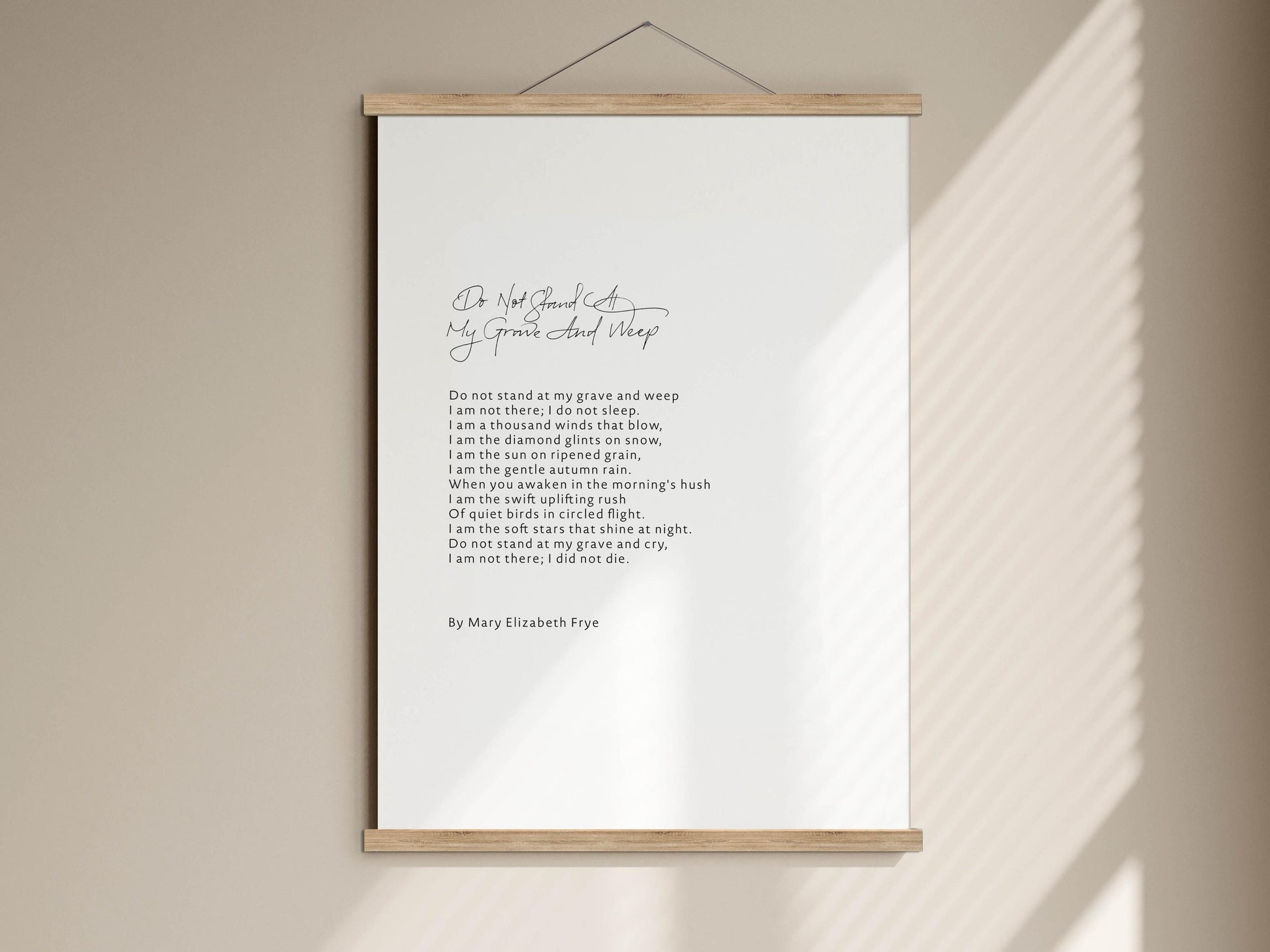 a white poster with a black handwritten poem on it, hanging on a wall.