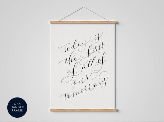 a framed print with a quote in elegant calligraphy that reads &quot;Today is the first of all of our tomorrows&quot;.