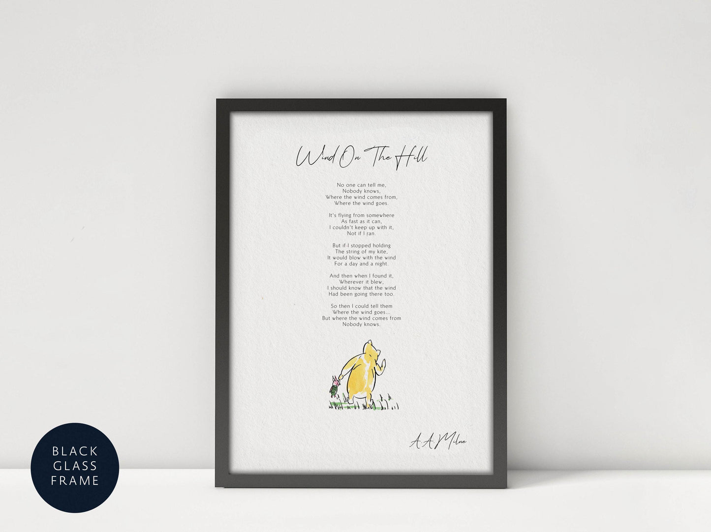 a framed print of a poem titled &quot;Wind on the Hill&quot; by A.A. Milne, accompanied by a small illustration of a yellow character.