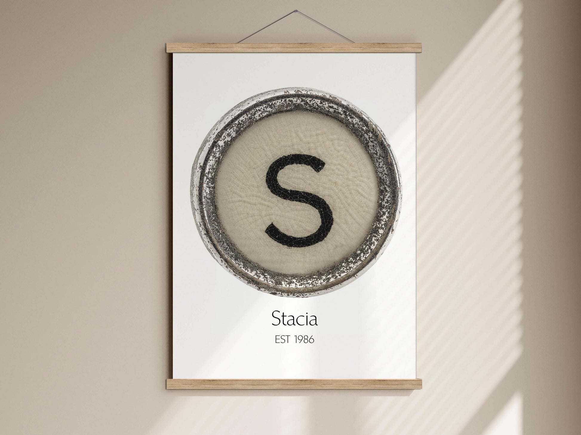 a poster with a circular design containing the letter &#39;S&#39; and the text &quot;Stacia EST 1986&quot; below it.