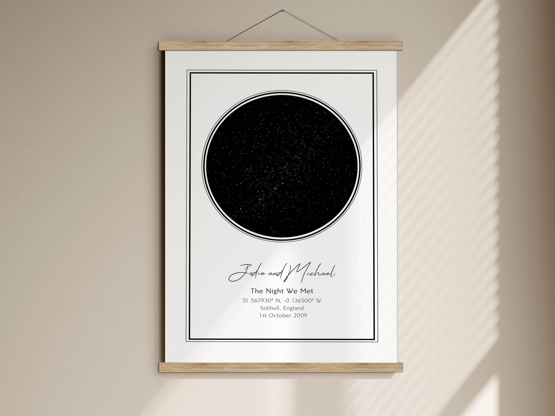 The image is a framed print featuring a black circle with a starry background, and it is hung on a wall.