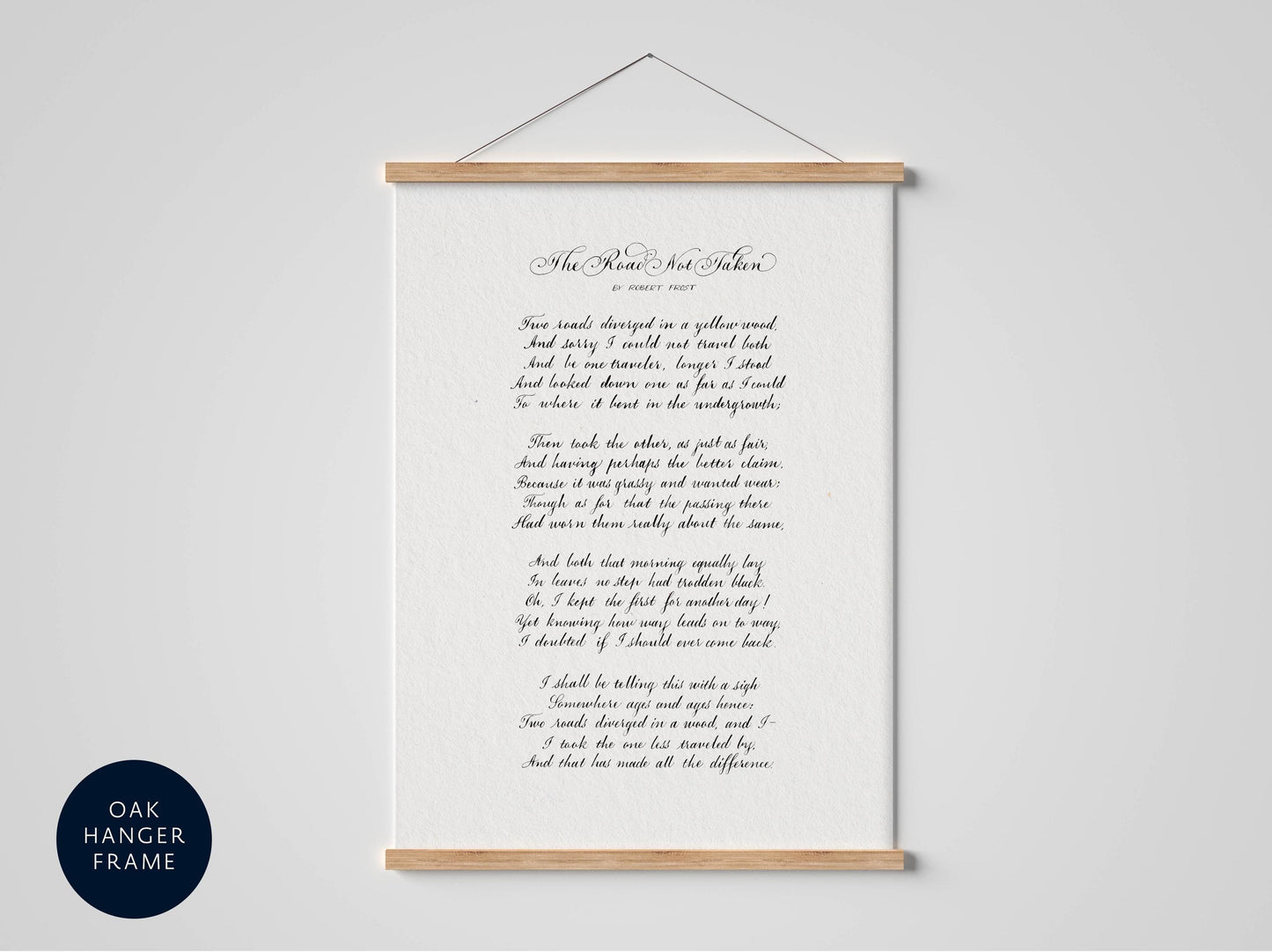 a framed black and white poem titled "The Road Not Taken" by Robert Frost, which is presented in a black frame against a white background.
