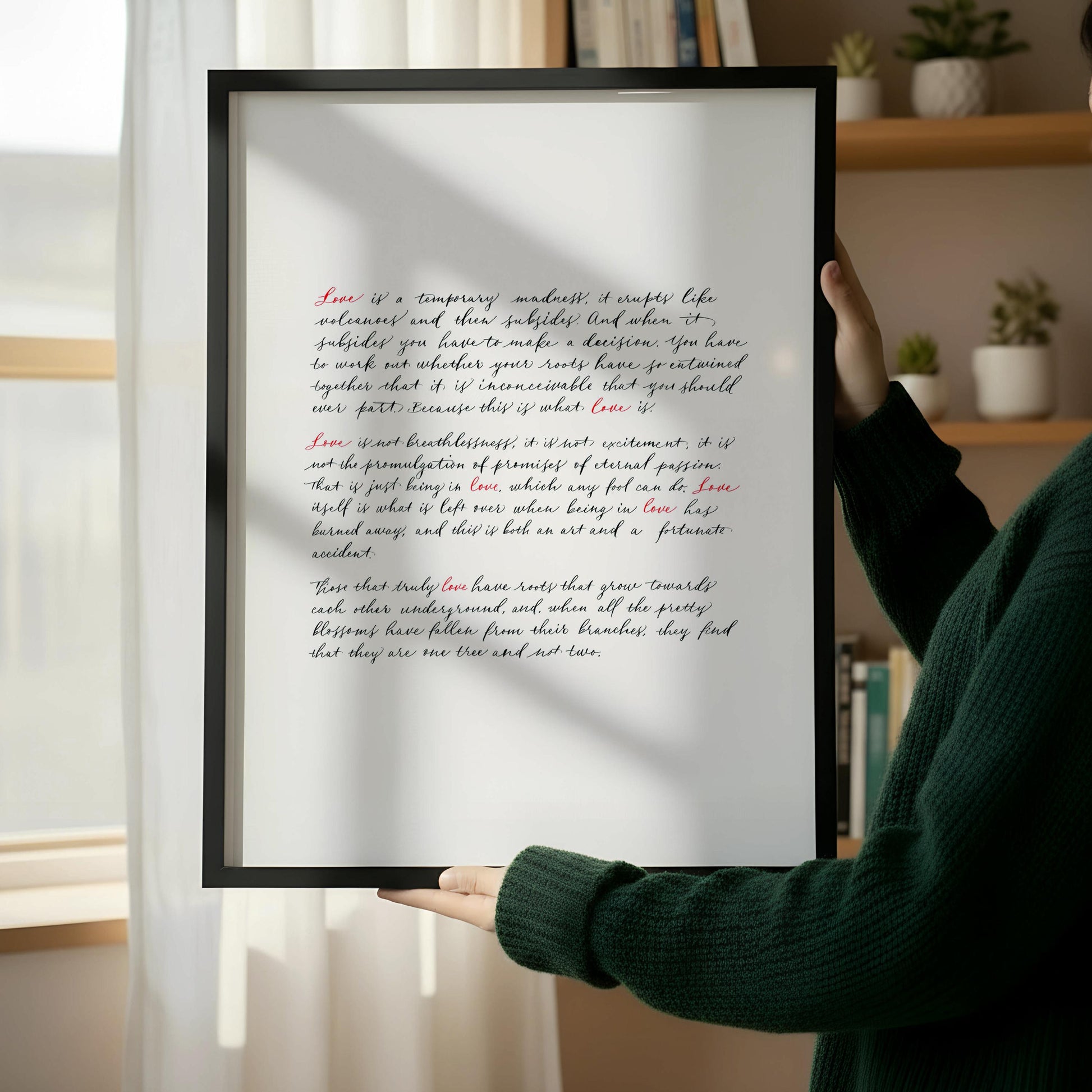 a wooden chair with a book resting on it, positioned next to a framed text on a white wall.