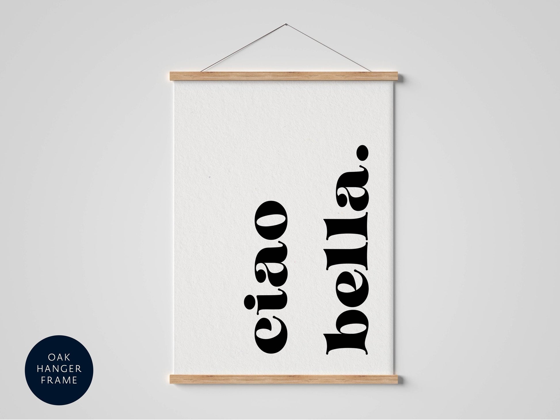 A framed poster with the text "eiao bella" in a bold, black font.