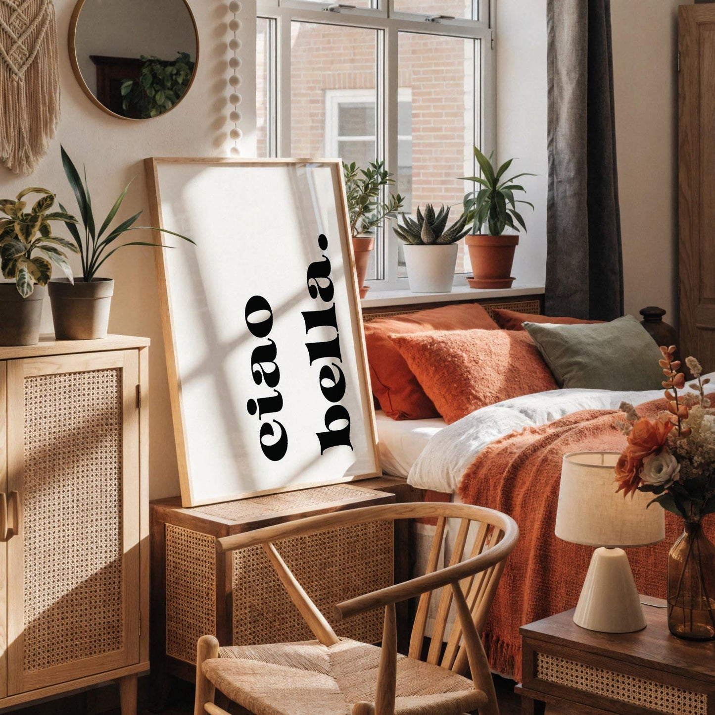 a minimalist workspace with a white desk, a framed poster with the text "ciao bella" in black, a white vase with dried flowers, a white mug, and a small white figurine.