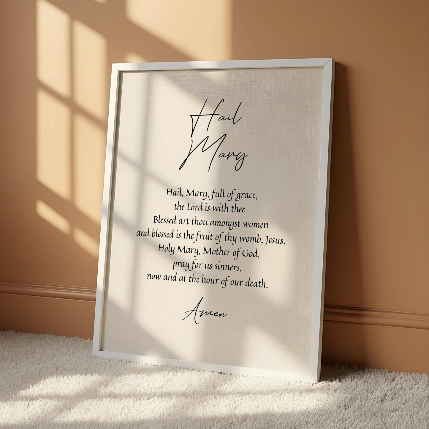 a framed poster with a religious text, hanging on a wall.