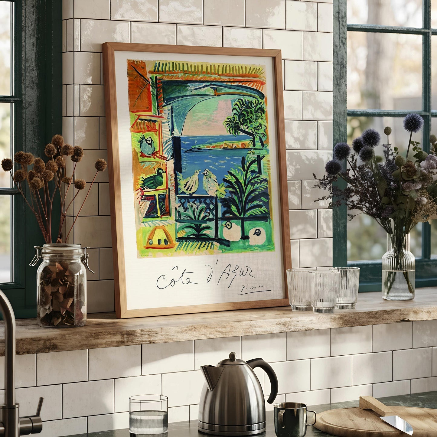 The image is a framed artwork depicting a colorful, abstract scene with various elements such as birds, palm trees, and a body of water.
