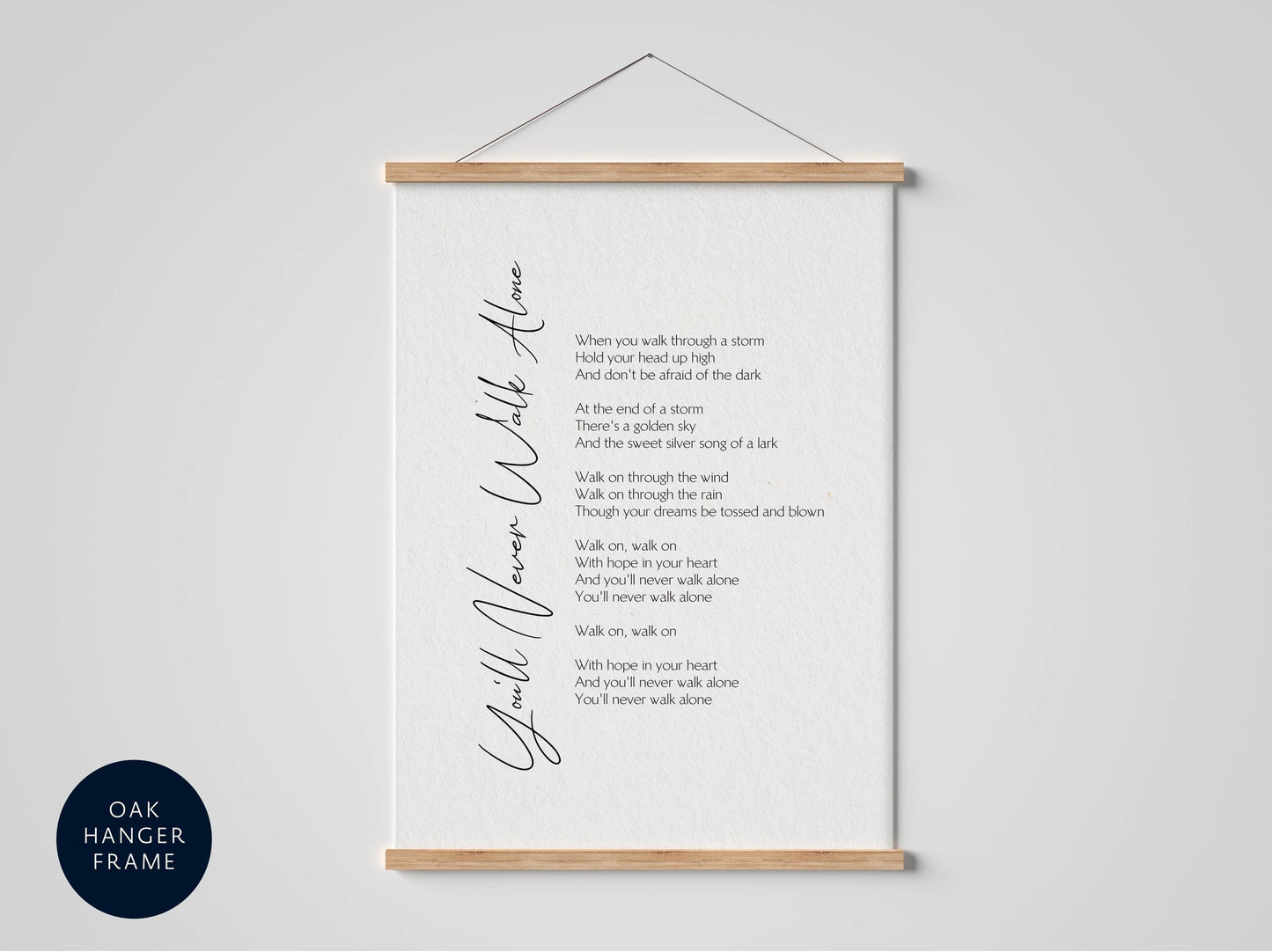 a framed black and white photograph of a poem titled "You'll Never Walk Alone" with a black and white color scheme.
