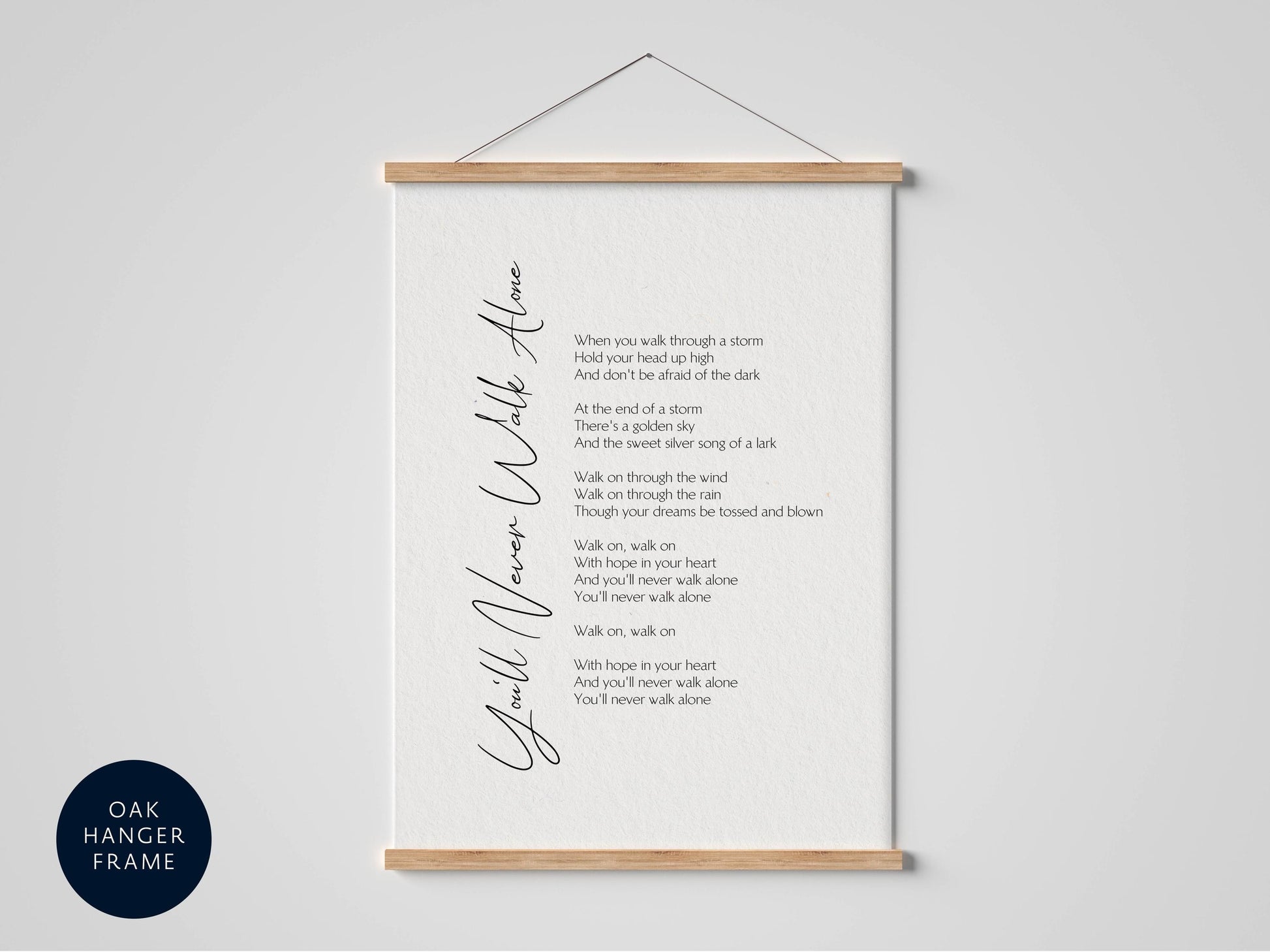 a framed black and white photograph of a poem titled "You'll Never Walk Alone" with a black and white color scheme.