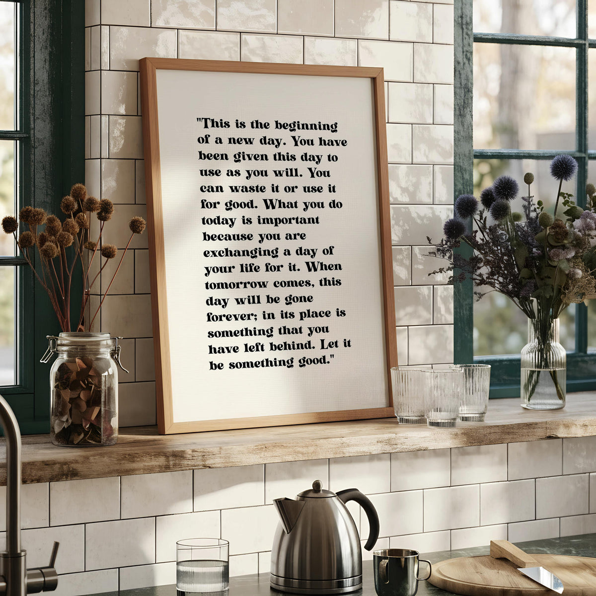 a quote on a wall, which is framed and hangs on a wall. The quote is in black text and reads: "This is the beginning of a new day. You have been given this day to use as you will. You can waste it or use it for good. What you do today is important because you are exchanging a day of your life for it. When tomorrow comes, this day will be gone forever; in its place is something that you have left behind. Let it be something good."