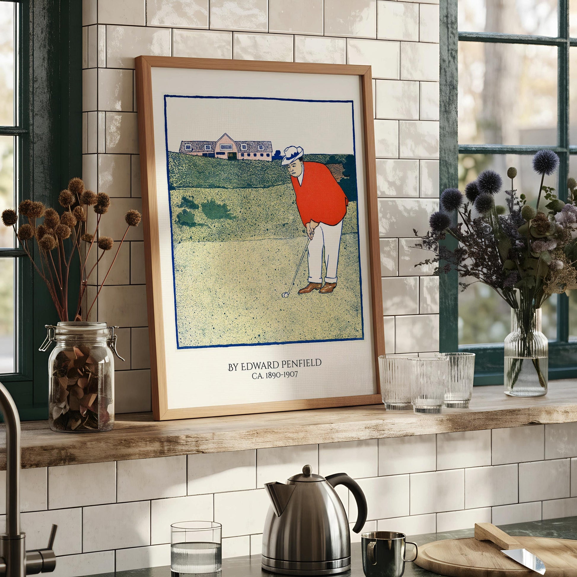 The image is a framed print depicting a golfer in an orange shirt and white pants, holding a golf club and preparing to take a swing.