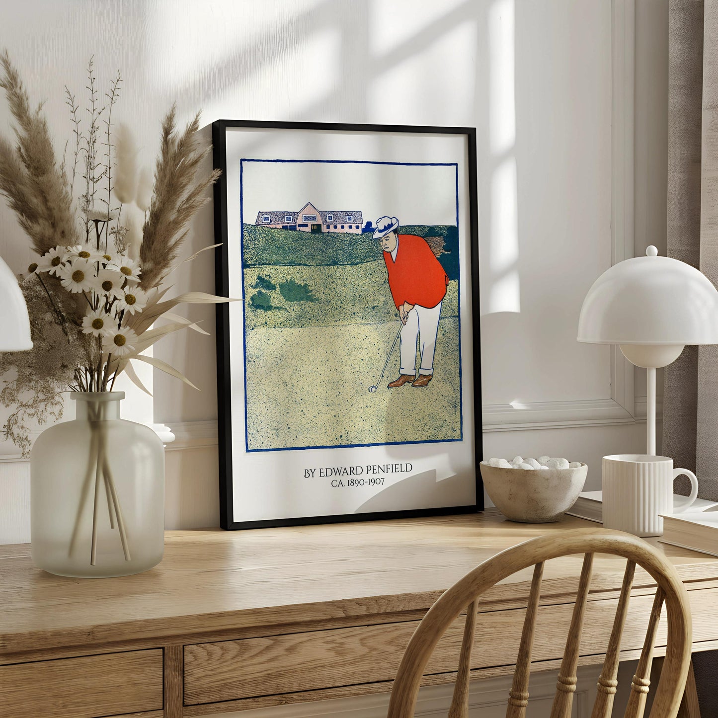 The image is a framed print depicting a golfer in an orange shirt and white pants, holding a golf club and preparing to take a swing on a golf course.