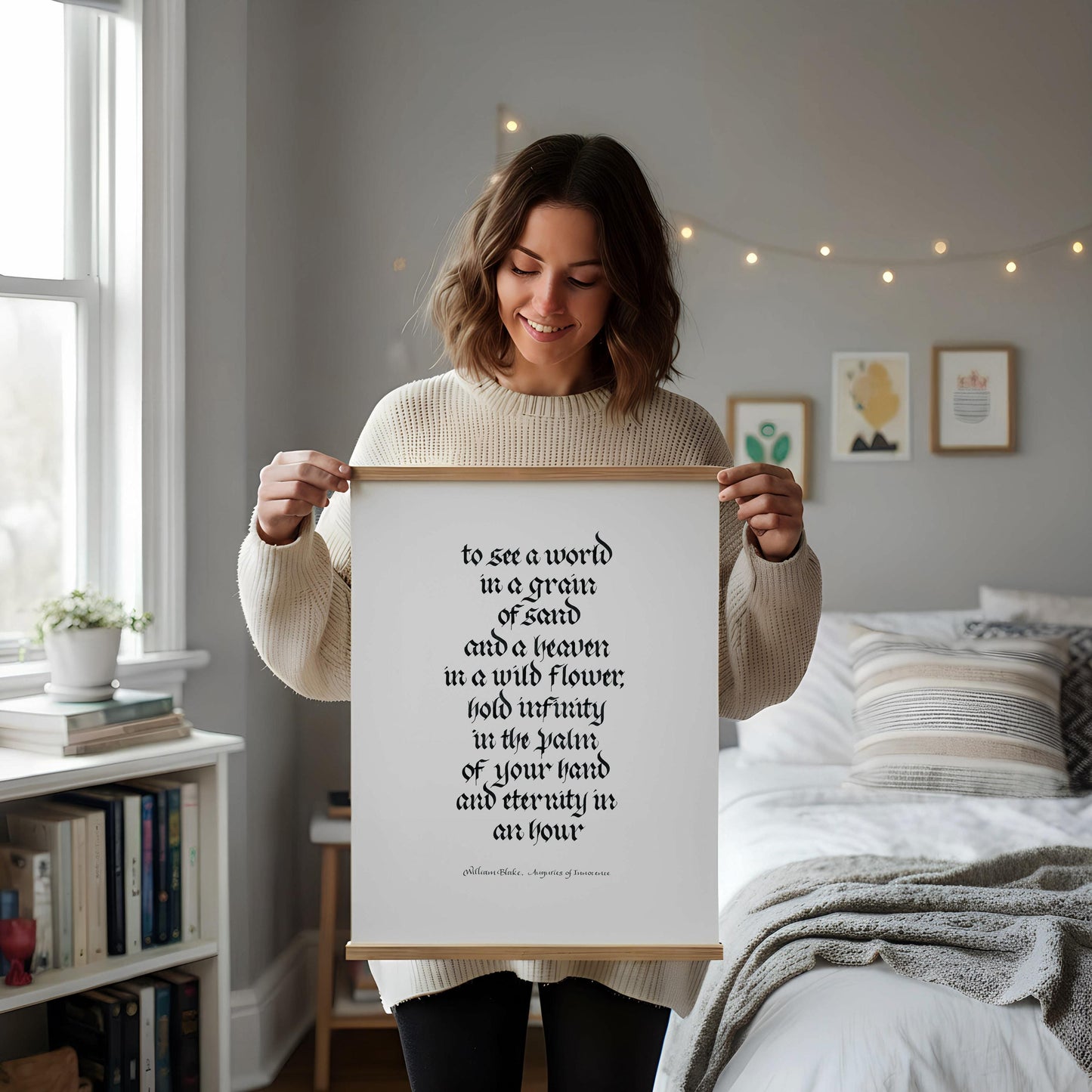 a framed quote on a white desk, surrounded by various objects such as a notebook, a cup, and a vase with dried flowers.