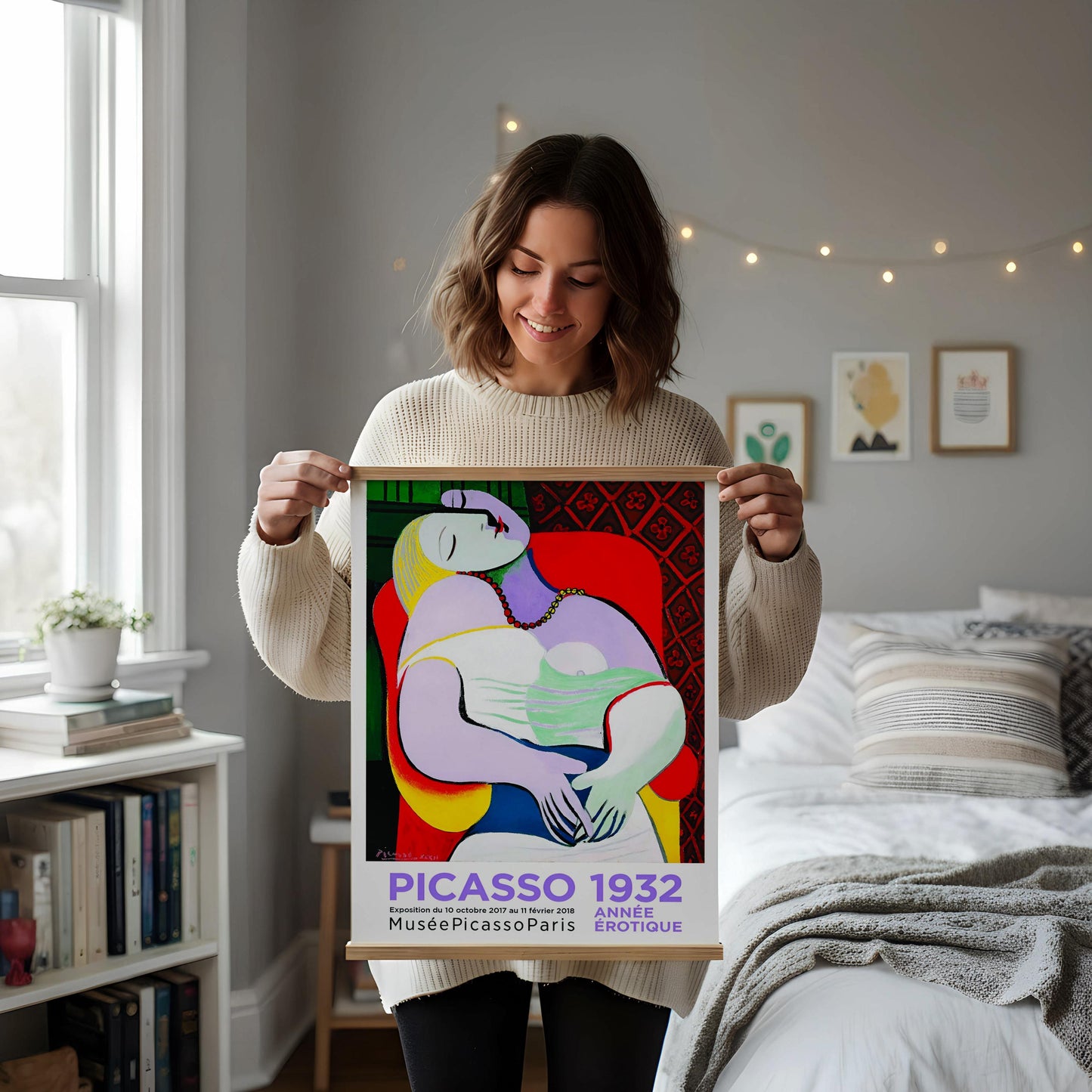 a framed poster of the cubist painting "PICasso 1922" displayed on a white desk, surrounded by various objects such as a notebook, a cup, and a vase.