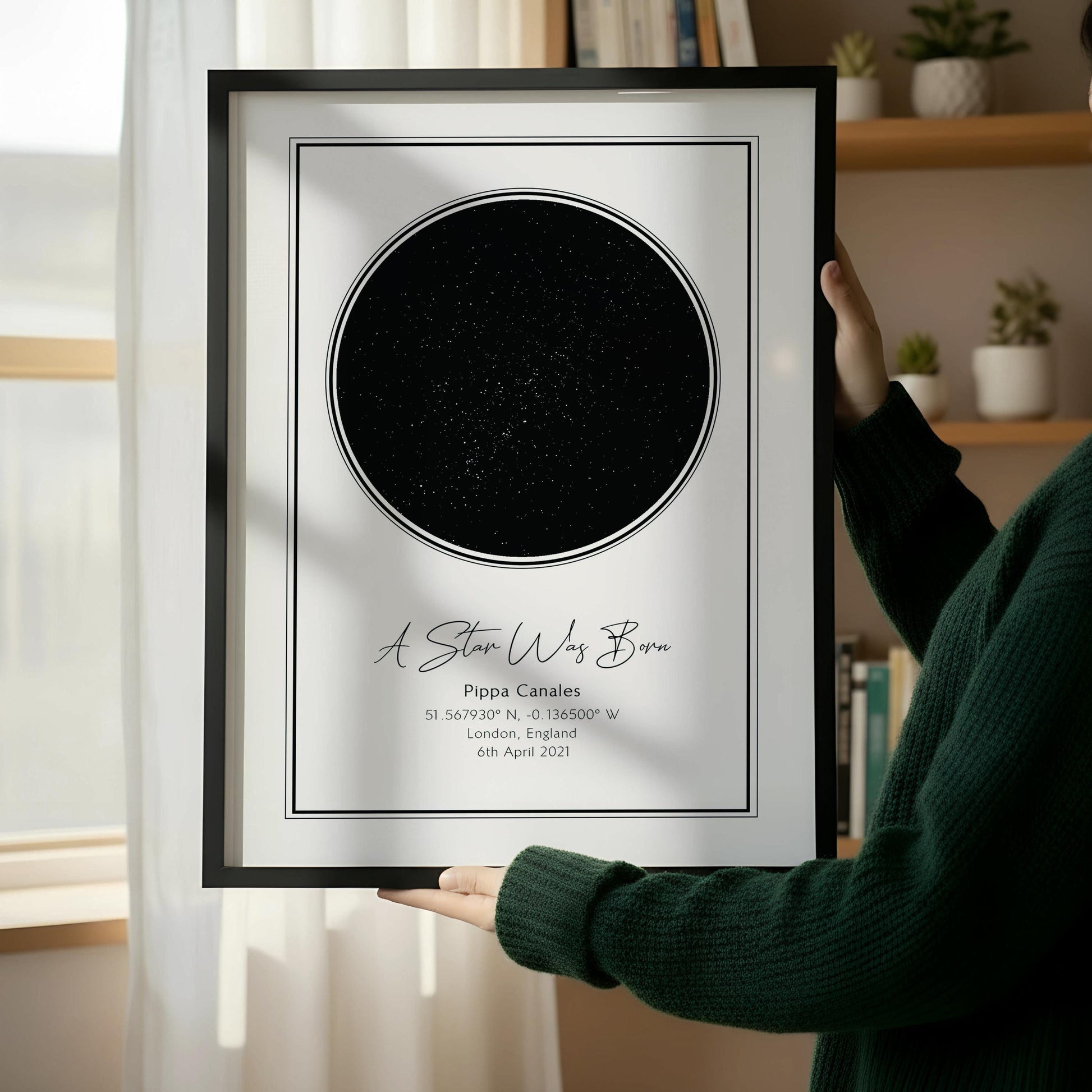 a wooden chair with a white book on it, placed next to a framed picture of a starry night sky.