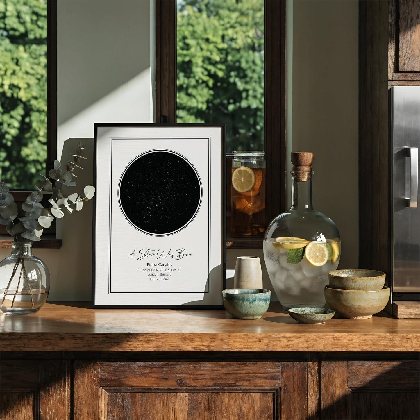 The image is a framed print featuring a black circle with a starry background, and it is hung on a wall.