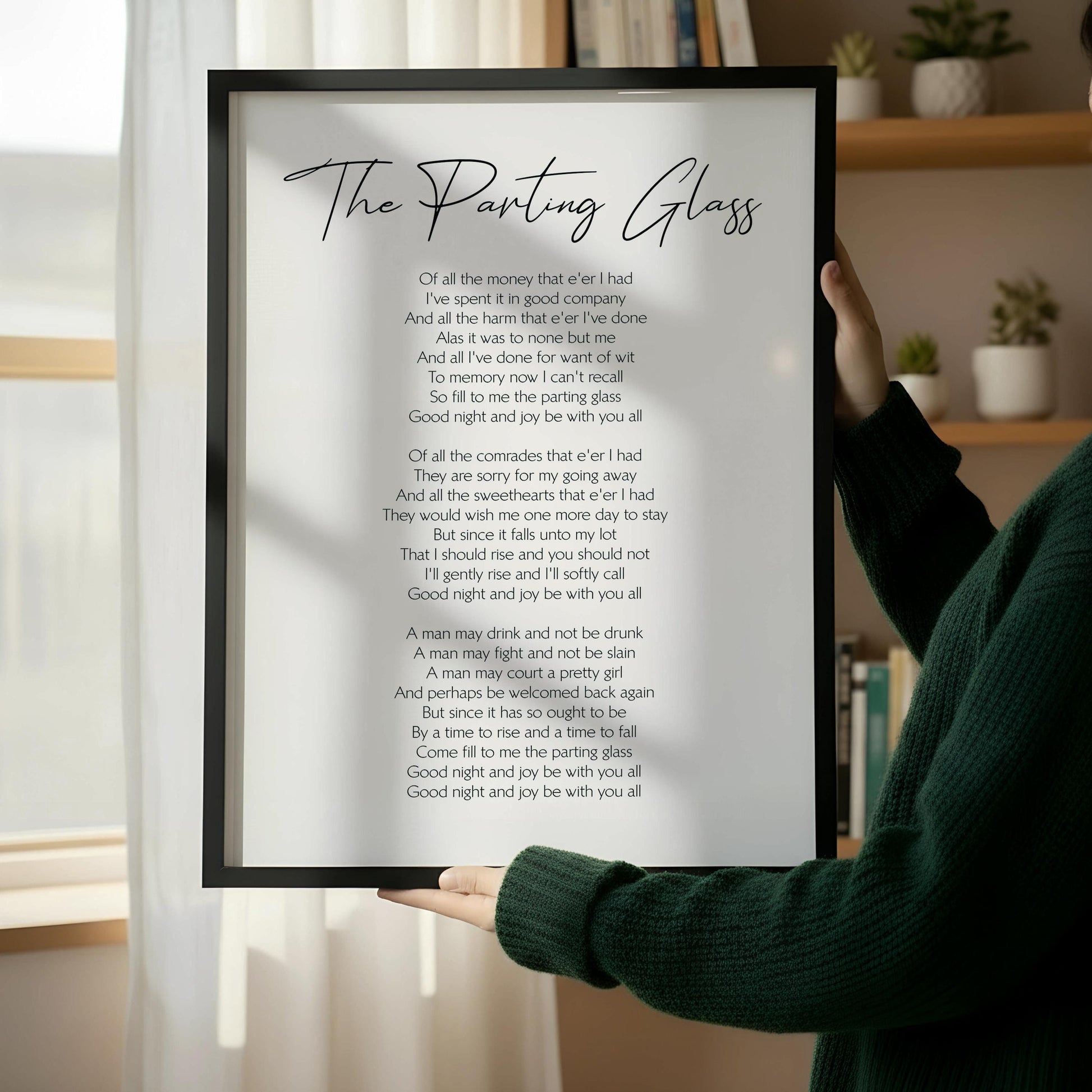 a wooden chair with a framed poem titled "The Panging Glass" leaning against a white wall.