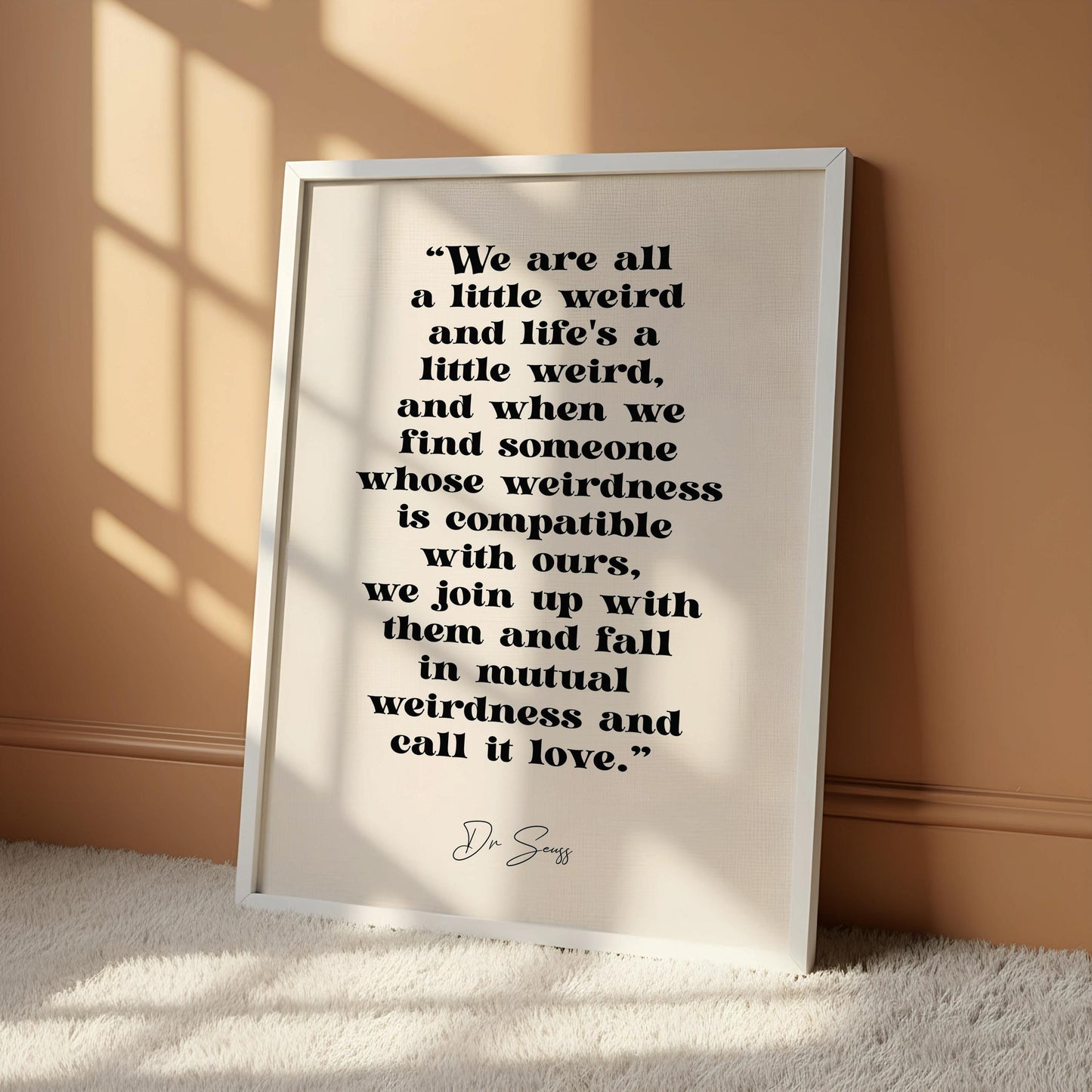 a quote by D.S. Passerby hanging on a wall, which reads: "We are all a little weird and life's a little weird, and when we find someone whose weirdness is compatible with ours, we join up with them and fall in mutual weirdness and call it love."