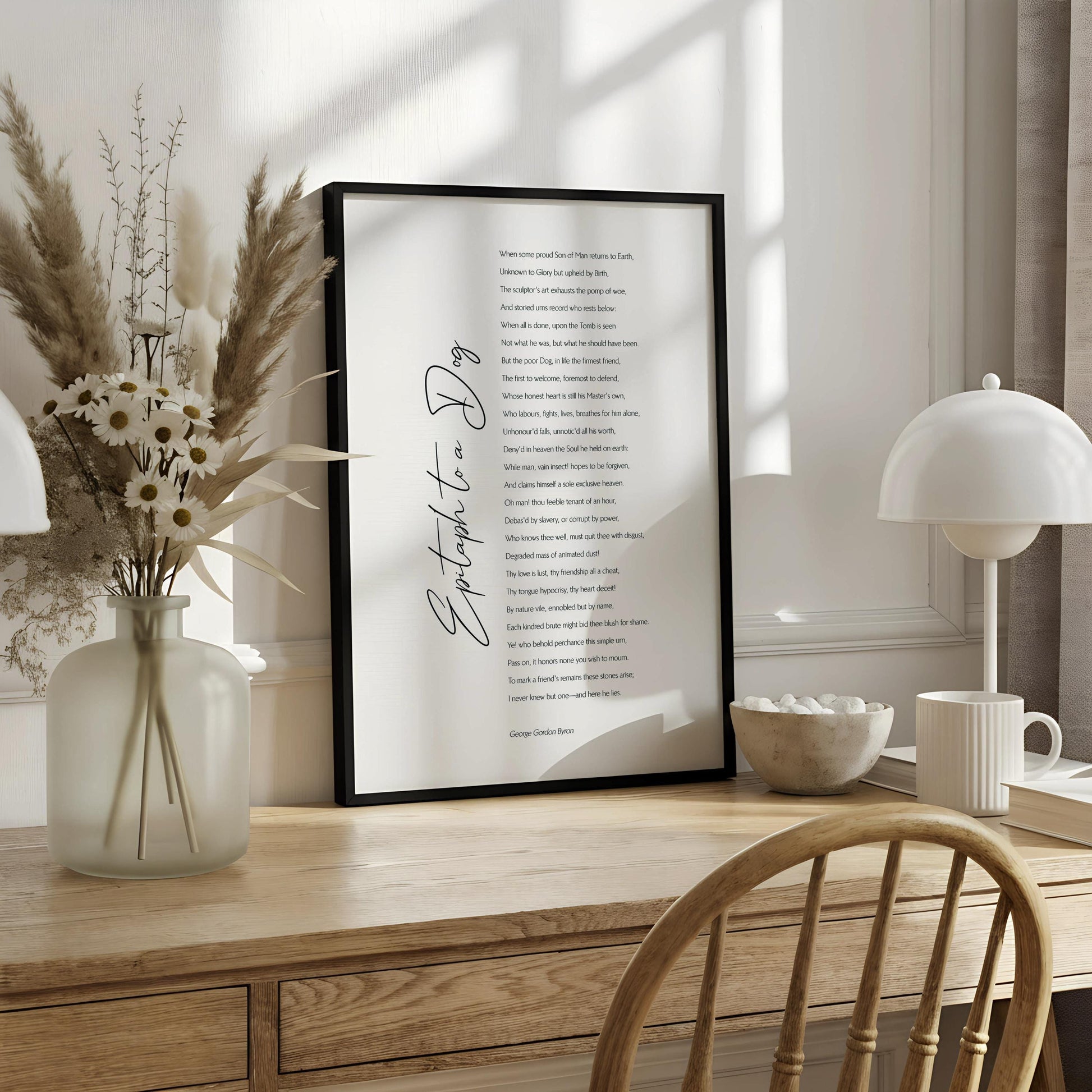 The image is a printed poster with a poem titled "Epitaph to a Dog" by George Gordon-Byon. The poster is hanging on a wall and features a wooden frame.